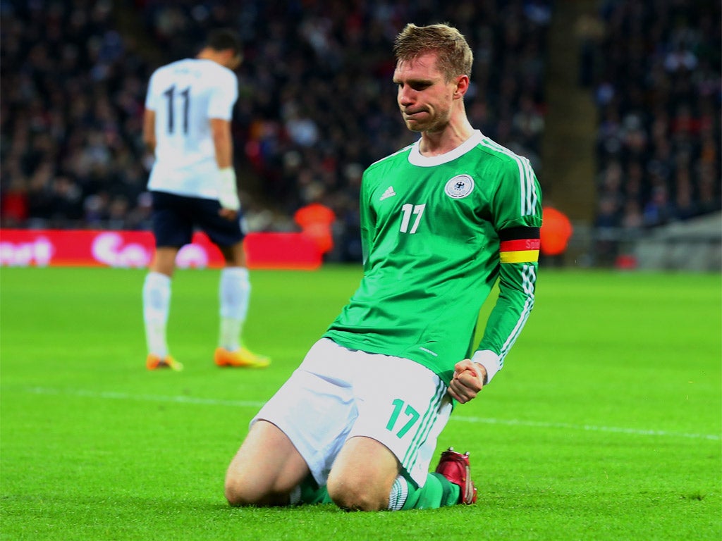 Mertesacker drops to his knees in celebration of his goal (Getty)