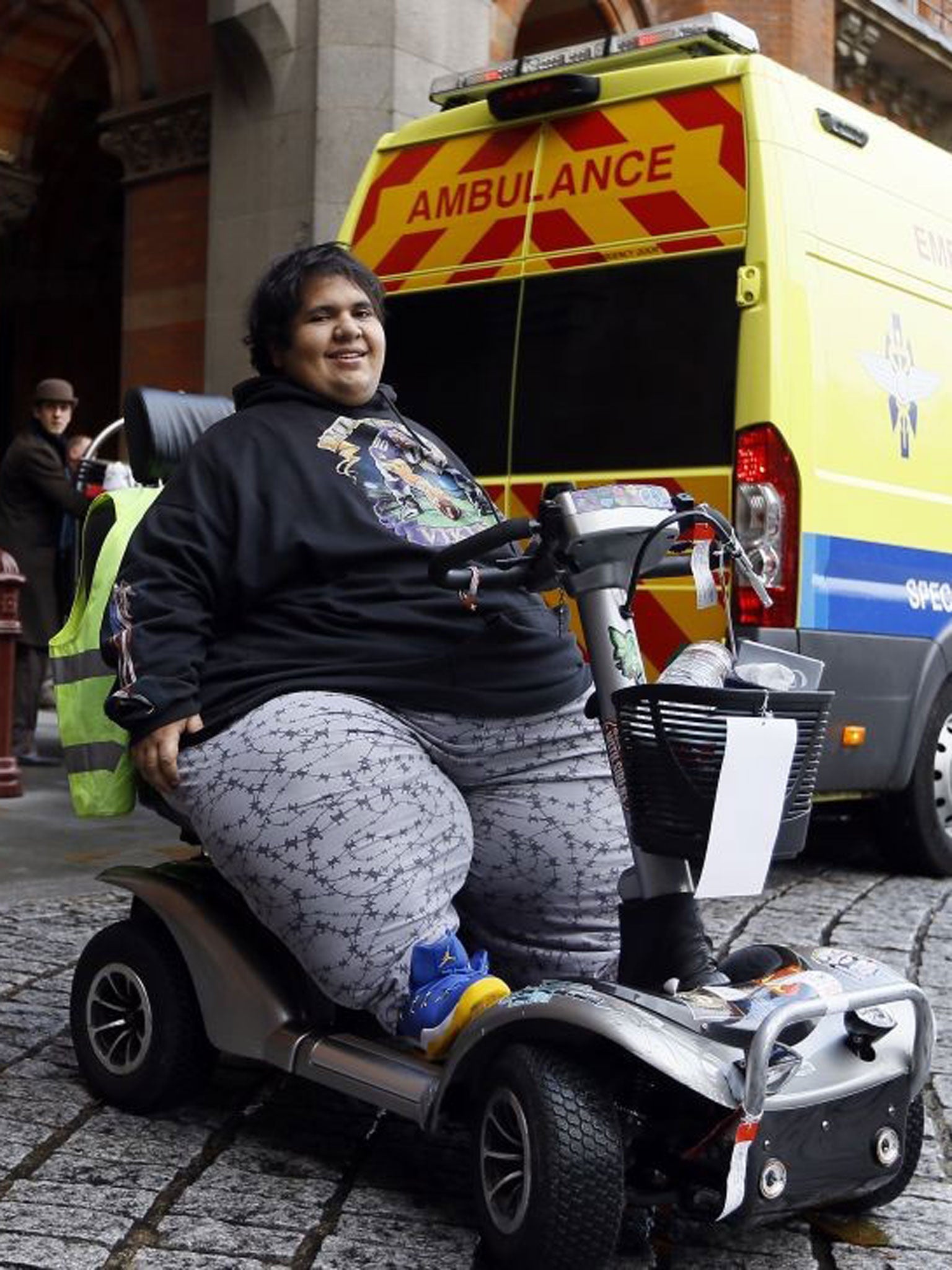 Kevin Chenais sits in his mobility scooter in front of an ambulance at St Pancras in London, Wednesday, 20 November 2013