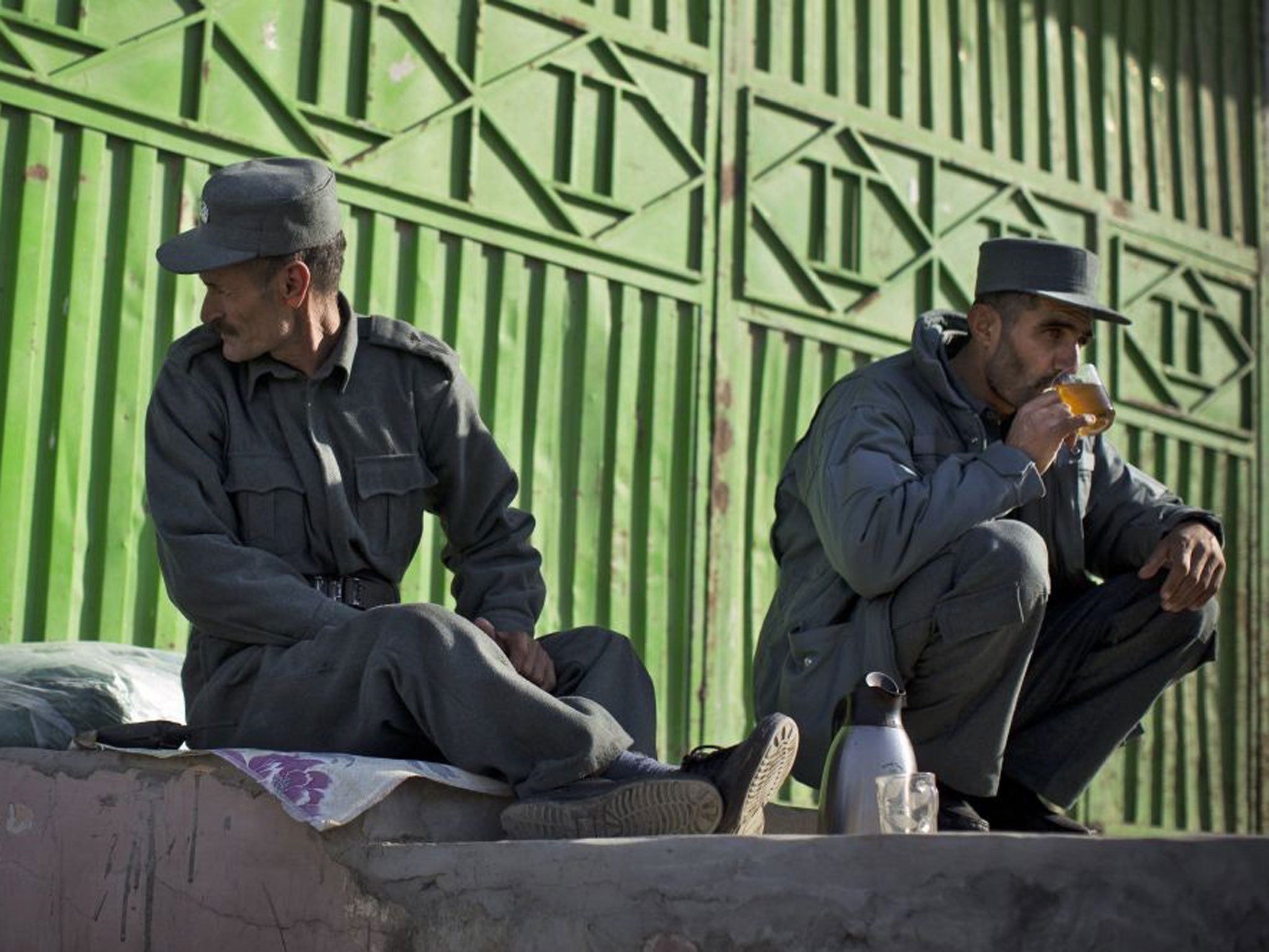 Afghan policemen enjoy a cup of tea at their checkpoint