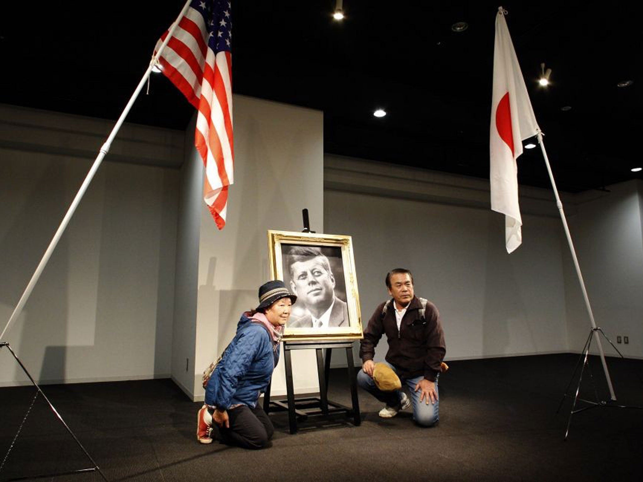 A Japanese couple pose with a portrait of the late U.S. President John F. Kennedy at a memorial venue specially set for his Japanese fans in Tokyo