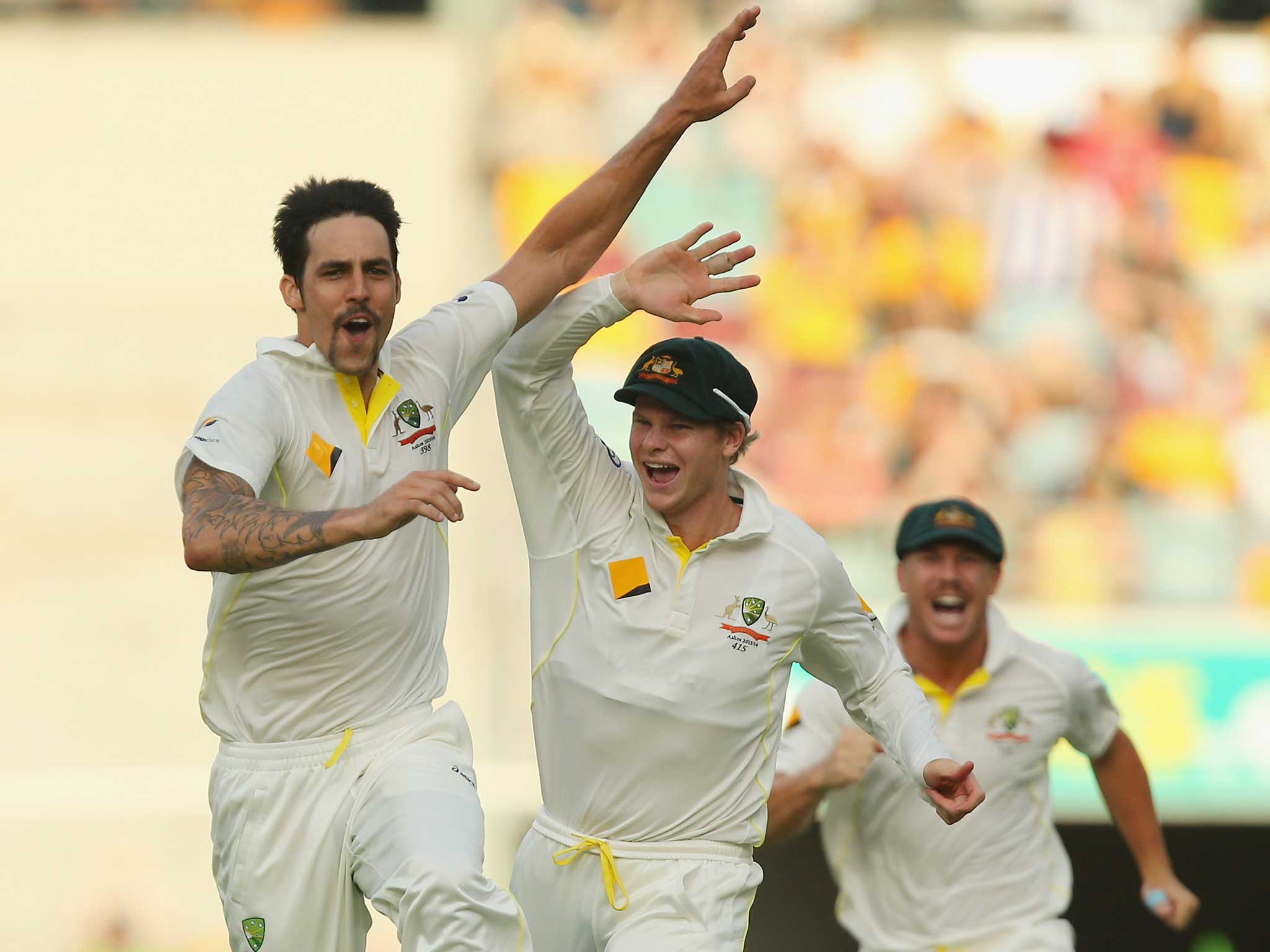 Mitchell Johnson of Australia celebrates with team mates Steve Smith and David Warner after dismissing Jonathan Trott