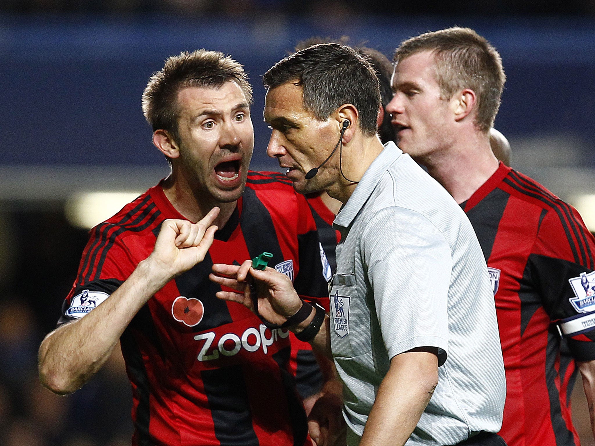 West Bromwich players protest to Andre Marriner after his late penalty award against them