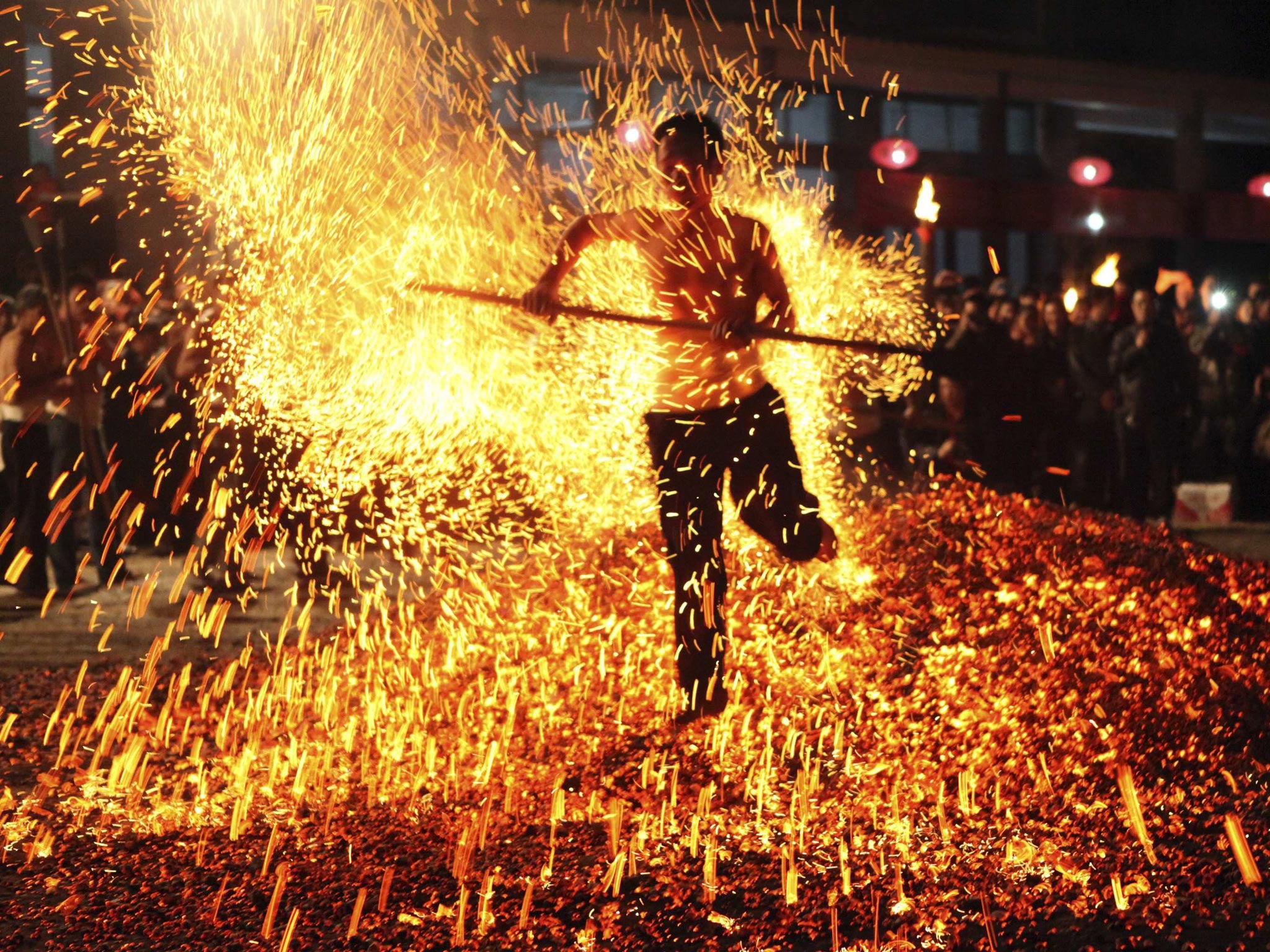 A man walks through burning charcoal as he participates in the traditional ritual called "Lianhuo", or "fire walking", in Pan'an county, Zhejiang province