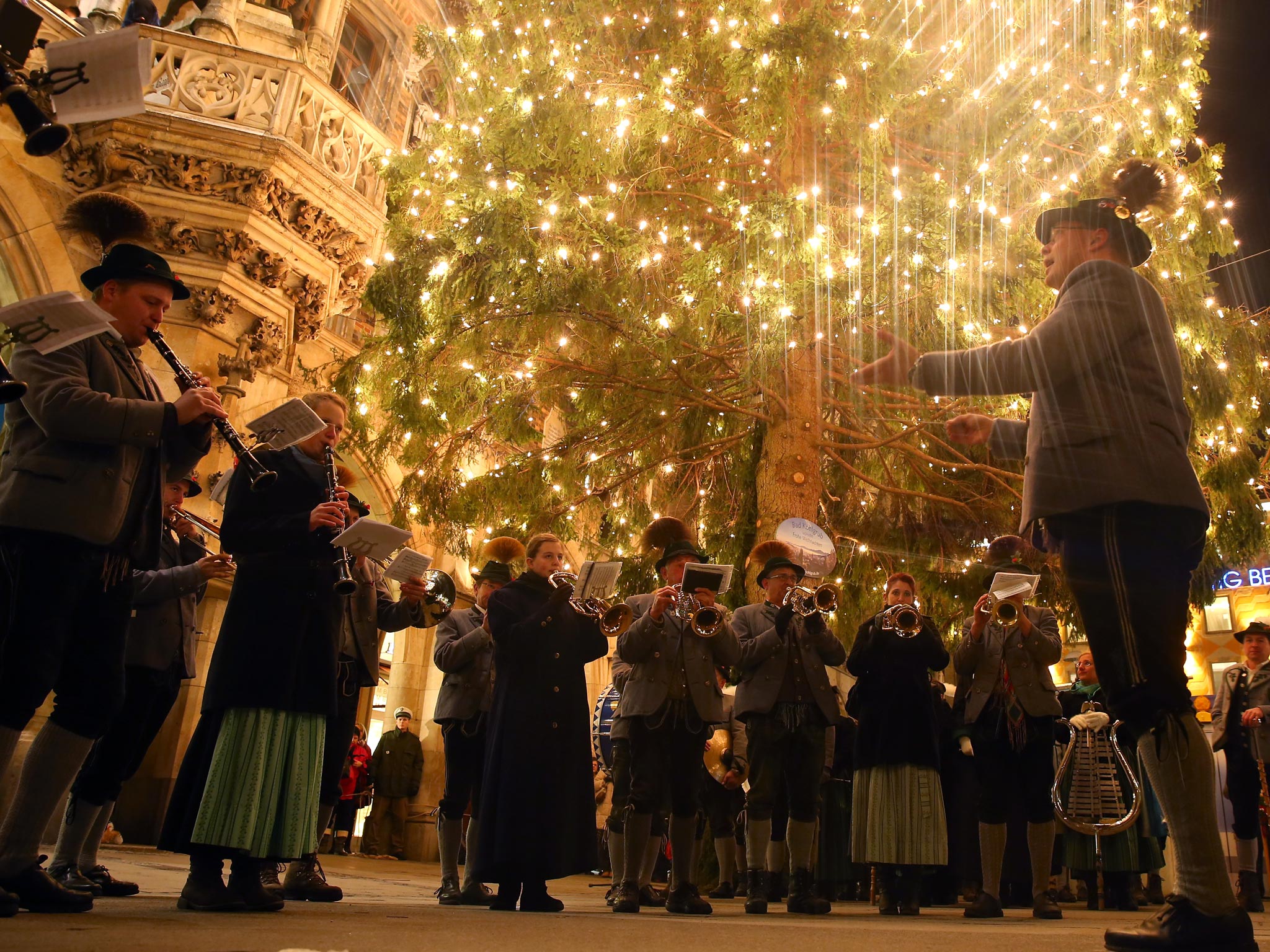 A traditional Bavarian brass band from the town Bad Kohlgrub dressed in typical Bavarian Lederhosen and Dirndl plays during the opening ceremony of the annual Christmas market at Marienplatz and the Town Hall