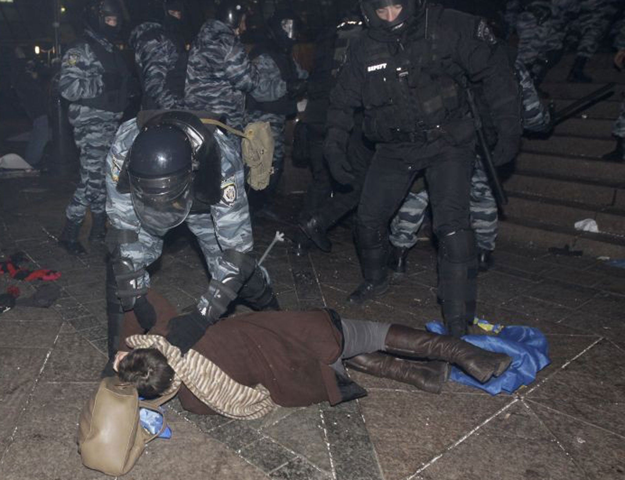 A protester is apprehended by police in Independence Square