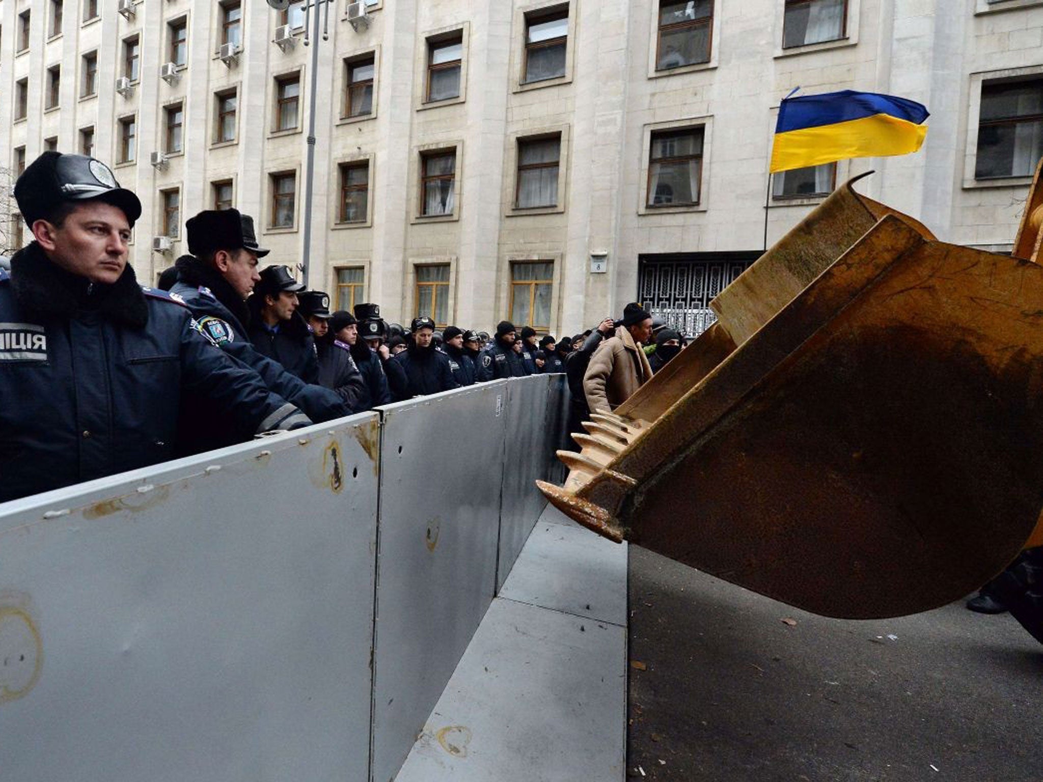 Police lines outside the presidential offices face up to the protesters' front-loader truck