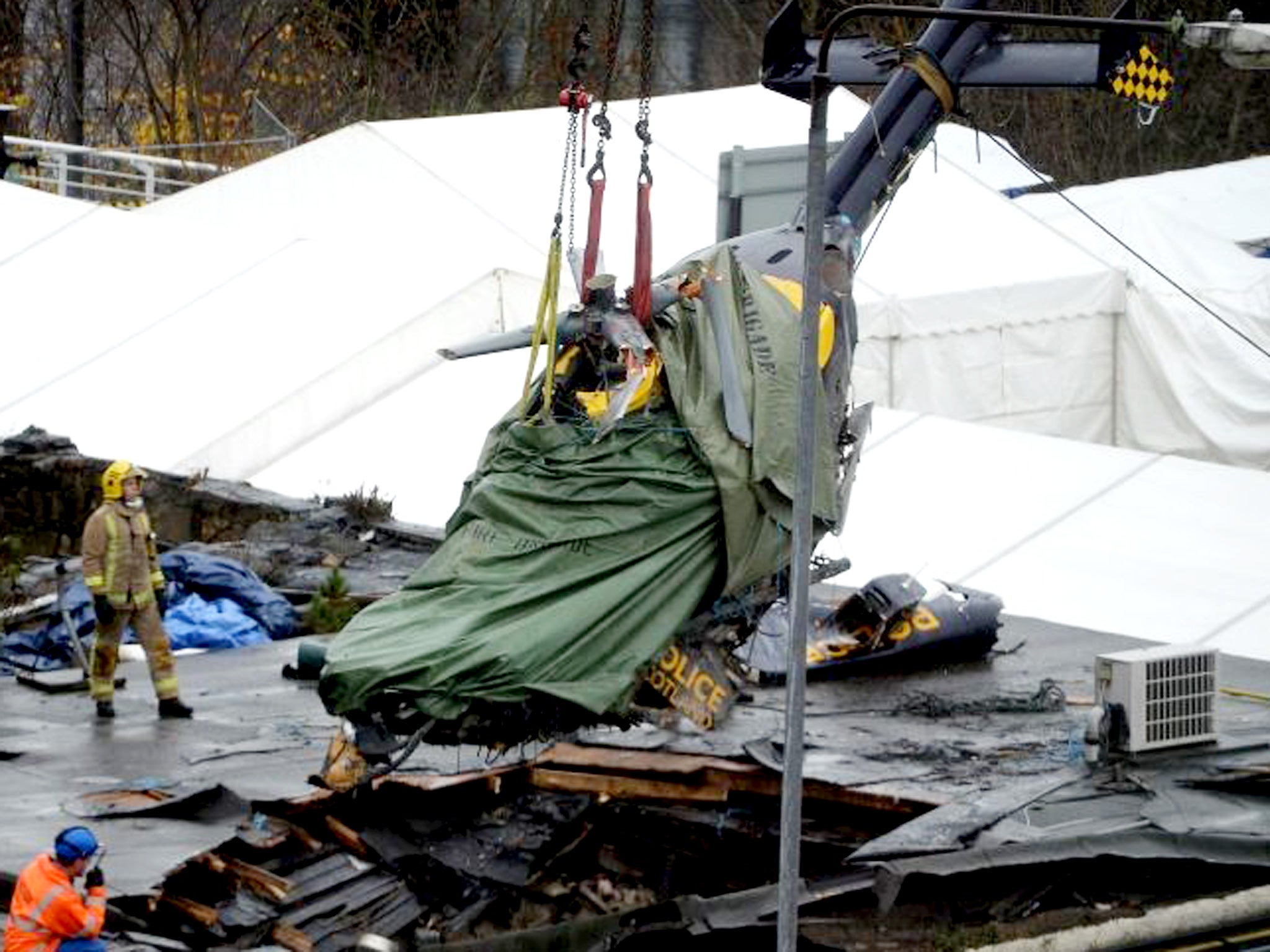 The police helicopter wreckage being lifted from the roof of the The Clutha Pub in Glasgow, Scotland