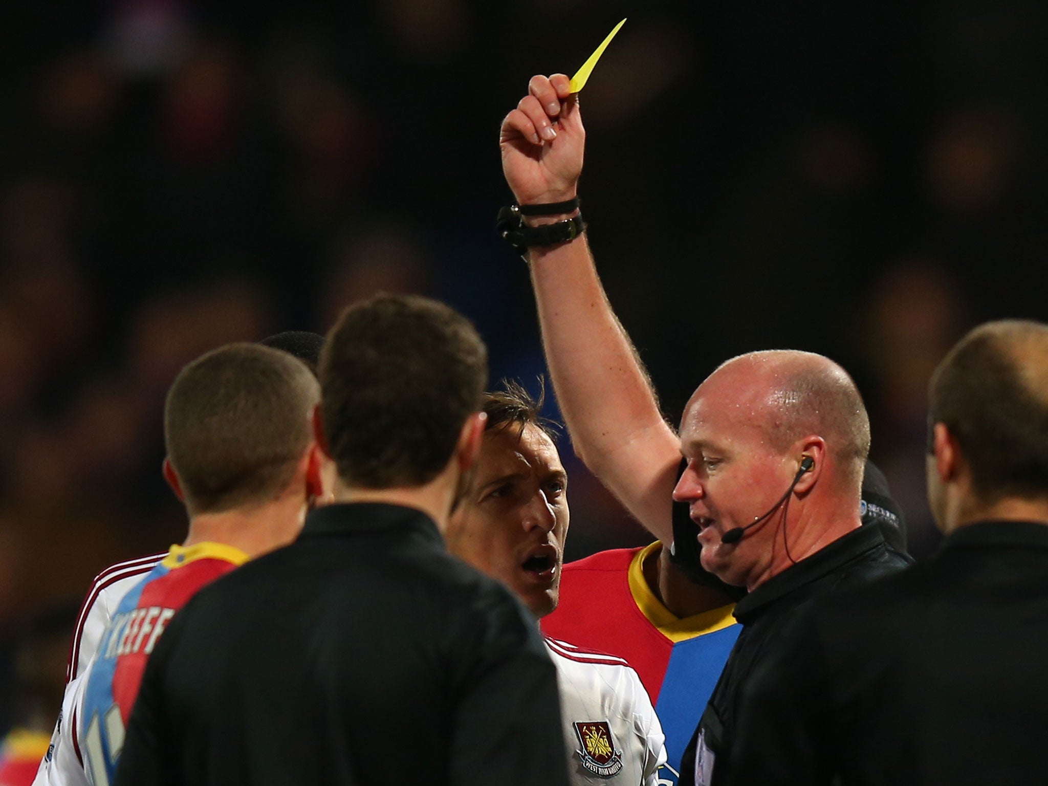 Ravel Morrison (obscured) is shown a yellow card after the final whistle for pushing Joel Ward in the face