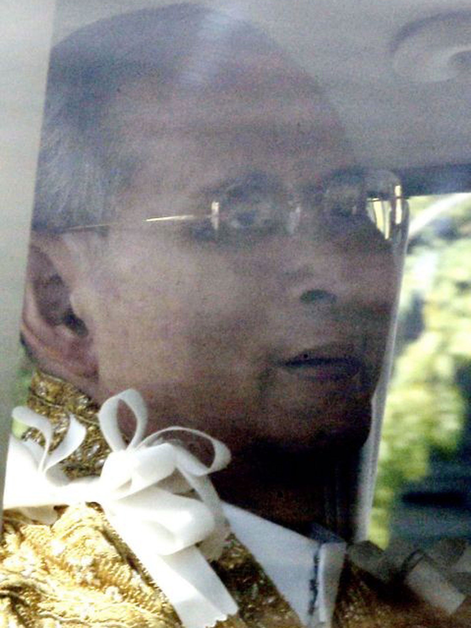 Thai King Bhumibol Adulyadej as he is driven past tens of thousands of well-wishers lining the streets around Klai Kangwon Palace for celebrations on his 86th birthday