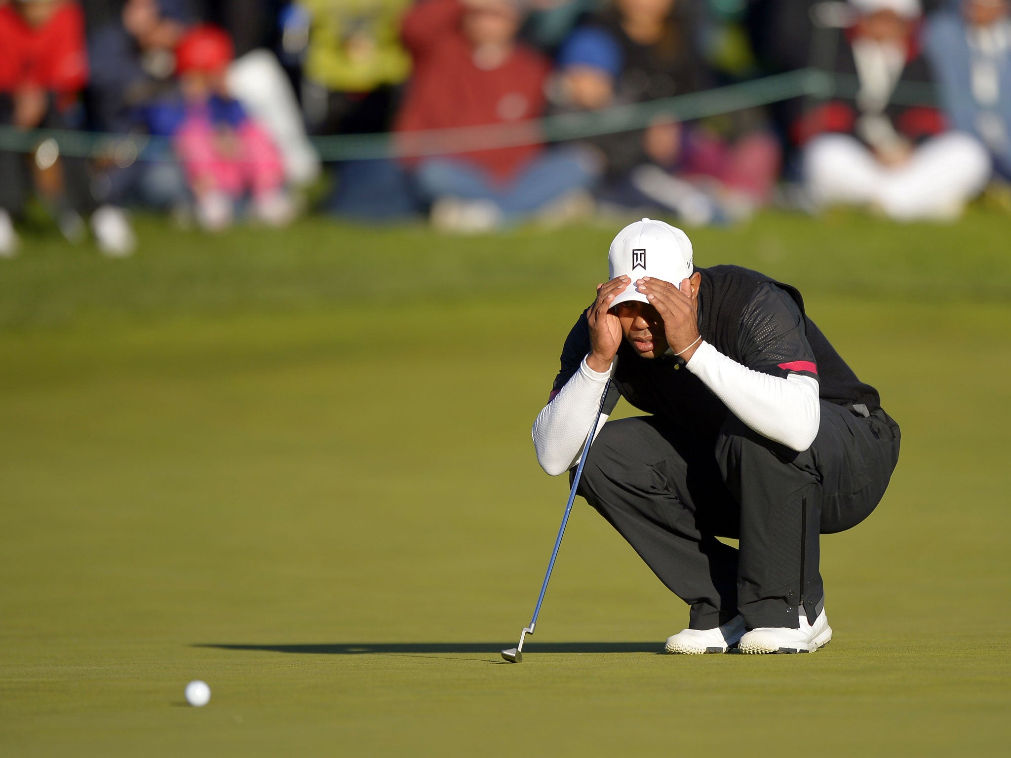 Tiger Woods lines up a putt on the 18th green at the World Challenge in California