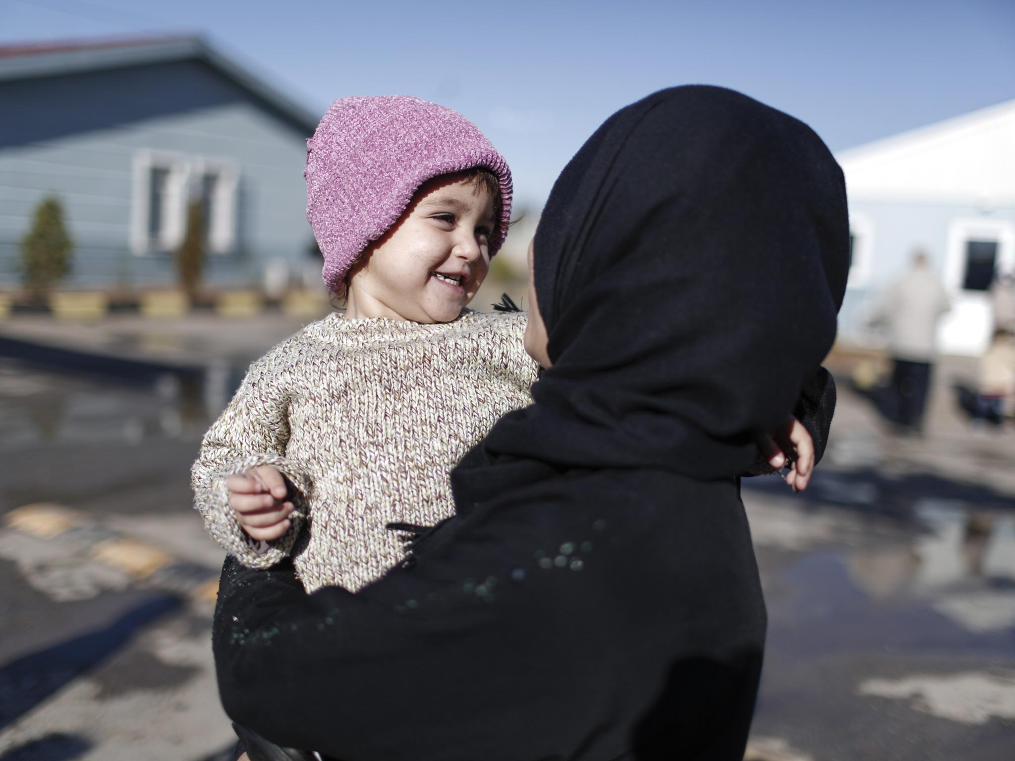 Two-year-old Zakia plays in the 'Container City' refugee camp