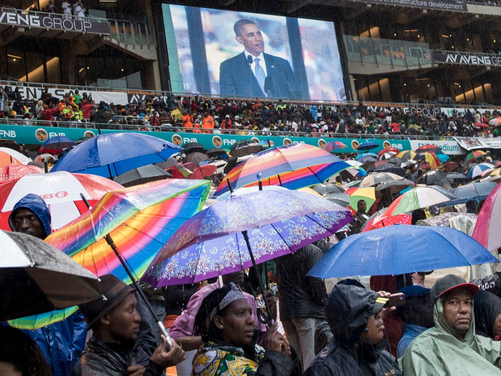 A giant screen shows US President Barack Obama delivering a speech during the memorial service for late South African President Nelson Mandela at Soccer City Stadium in Johannesburg on December 10, 2013.