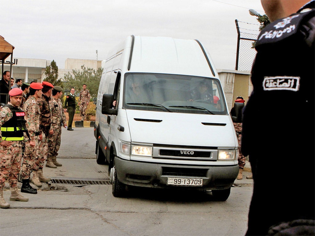 A vehicle carrying Abu Qatada arrives at the Jordanian military court in Amman