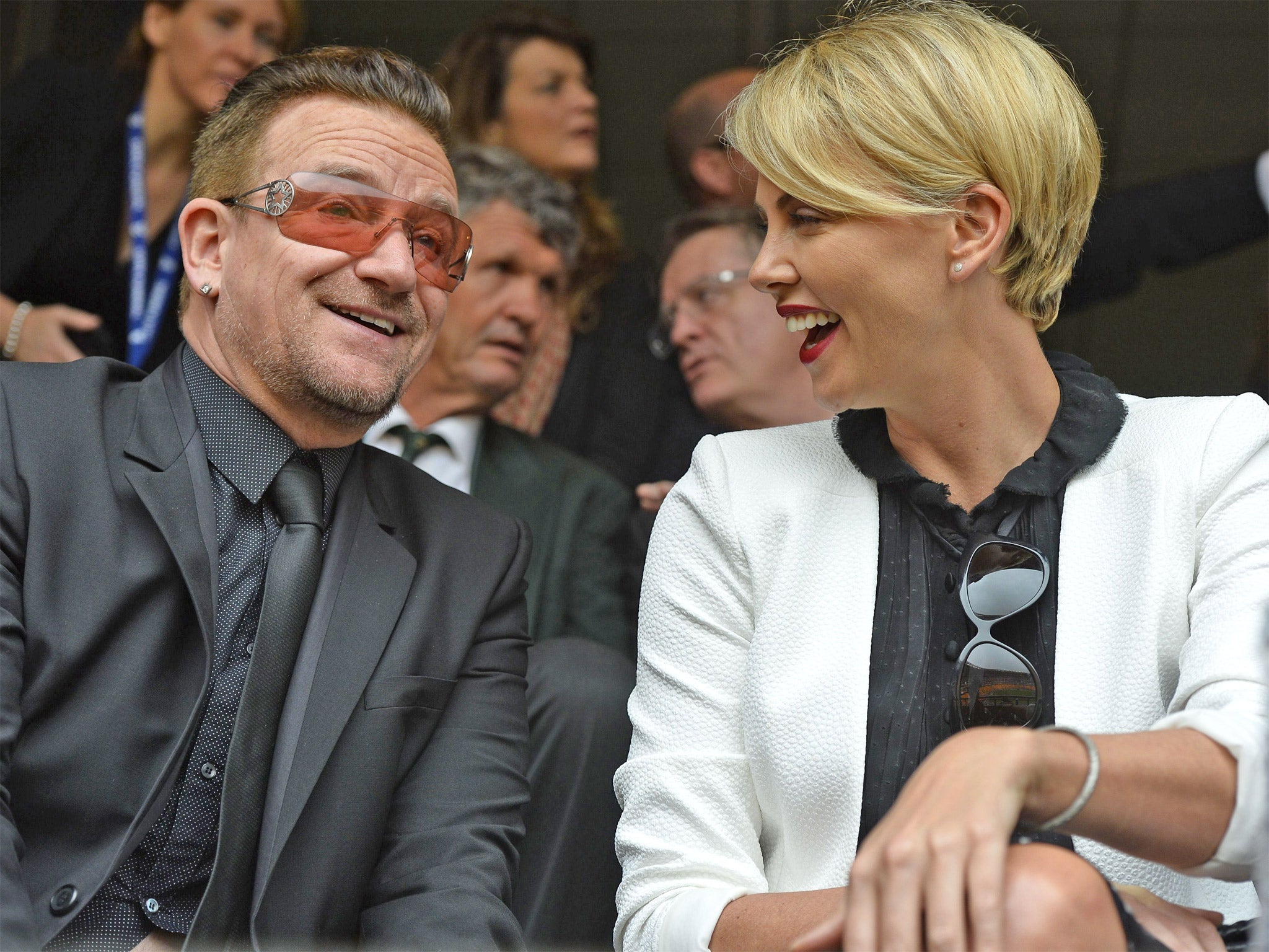 U2 singer Bono sits next to South African actress Charlize Theron (Getty)