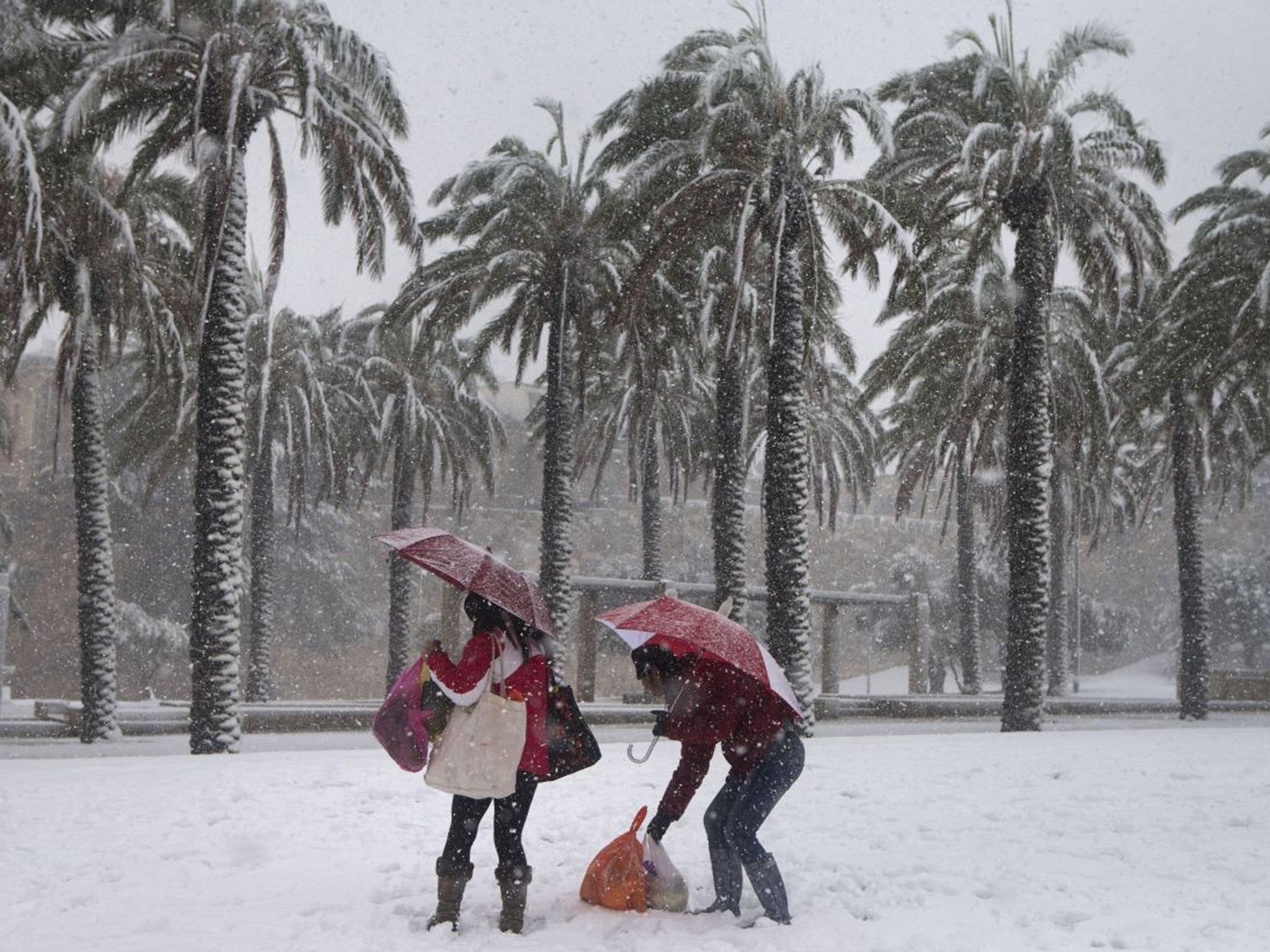 Israelis walk in the snow outside Jerusalem's old city