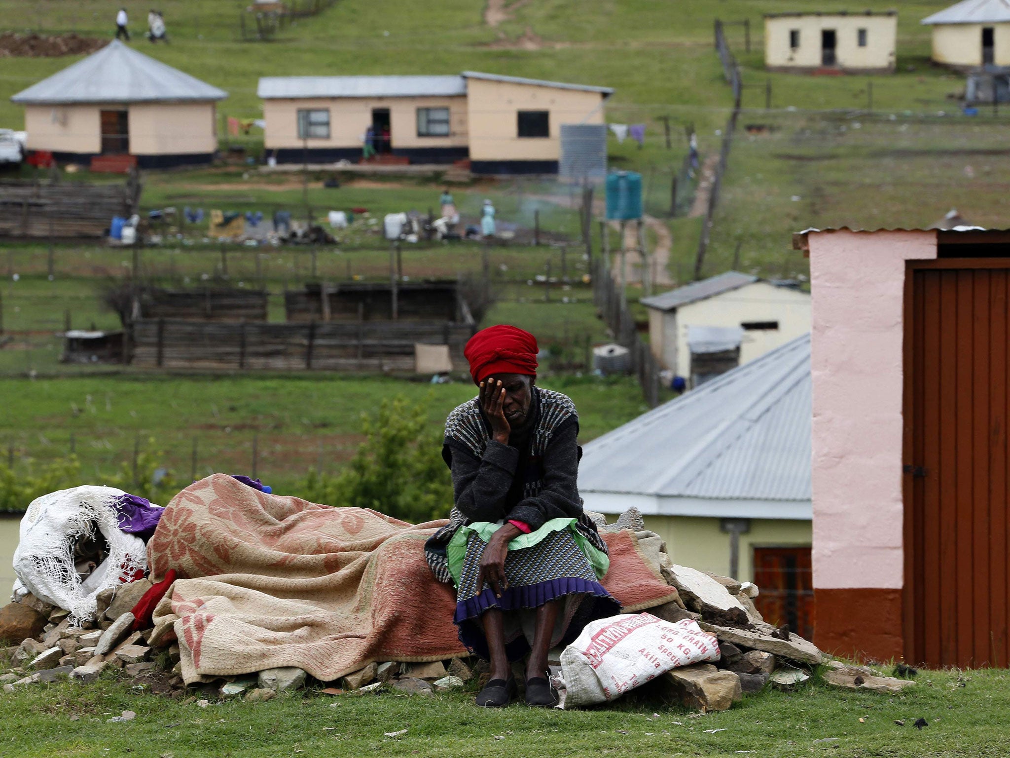 A villager sits in her garden at the perimeter of Nelson Mandela’s property in Qunu, 559 miles south of Johannesburg