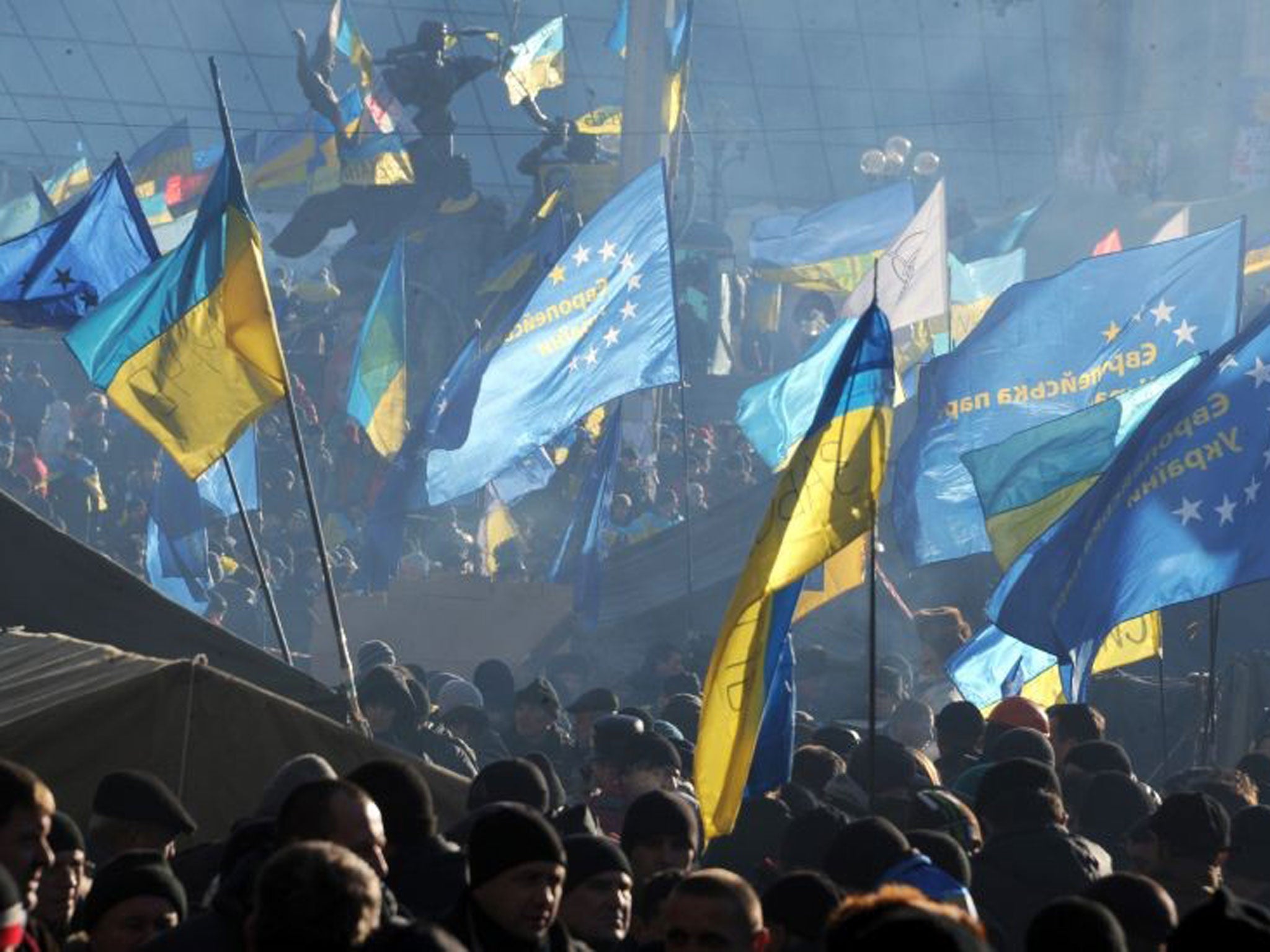 Protesters waving EU and Ukrainian flags in Kiev yesterday