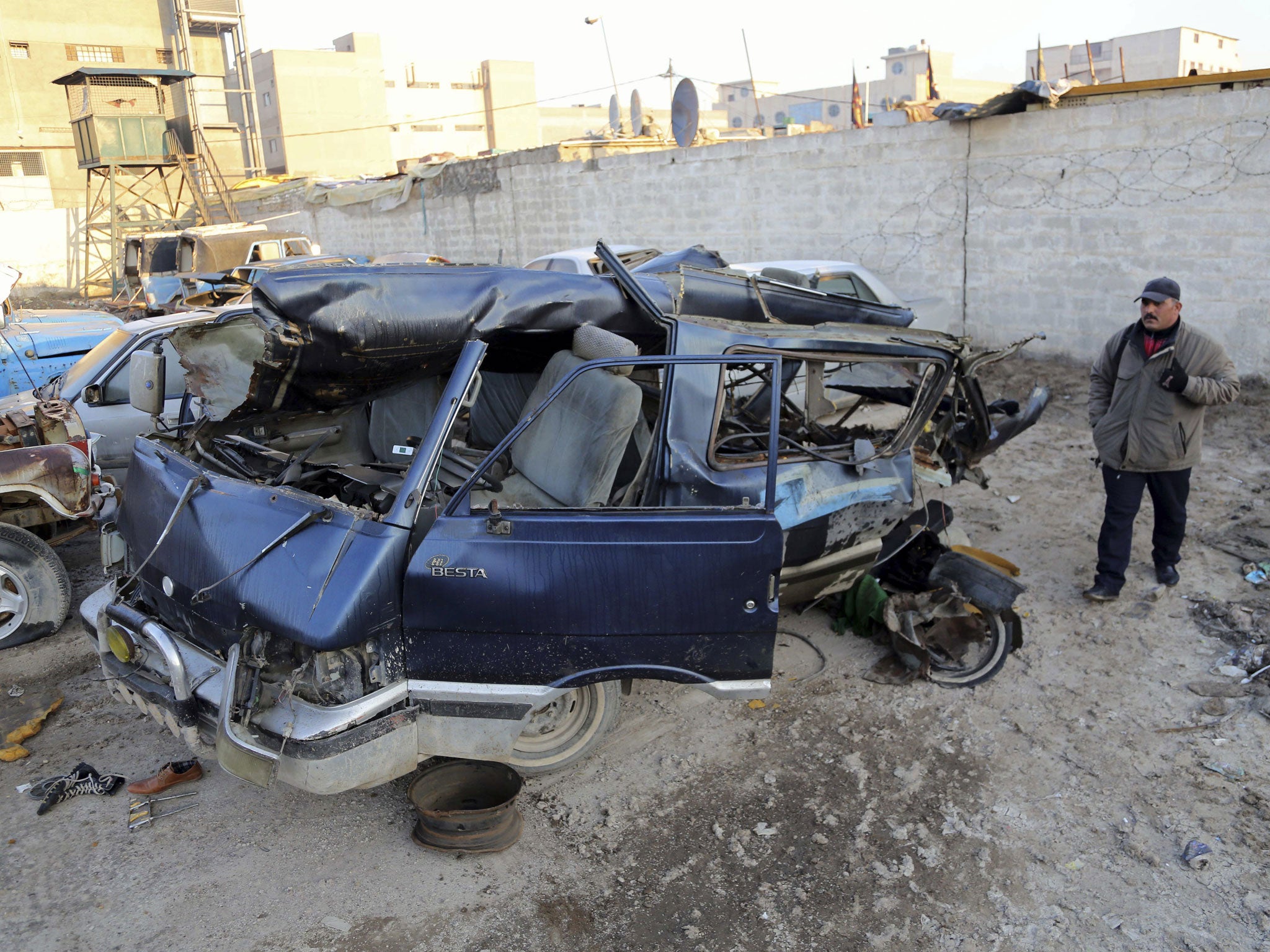 An Iraqi man inspects damaged vehicles in a car bomb attack in Baghdad - Several bombings have hit different parts of Baghdad and the surrounding area