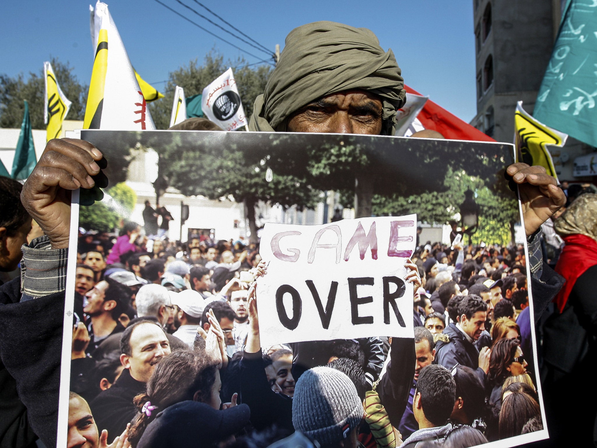 A supporter of the moderate Islamist Ennahda party holds a poster during a rally in Sidi Bouzid, central Tunisia