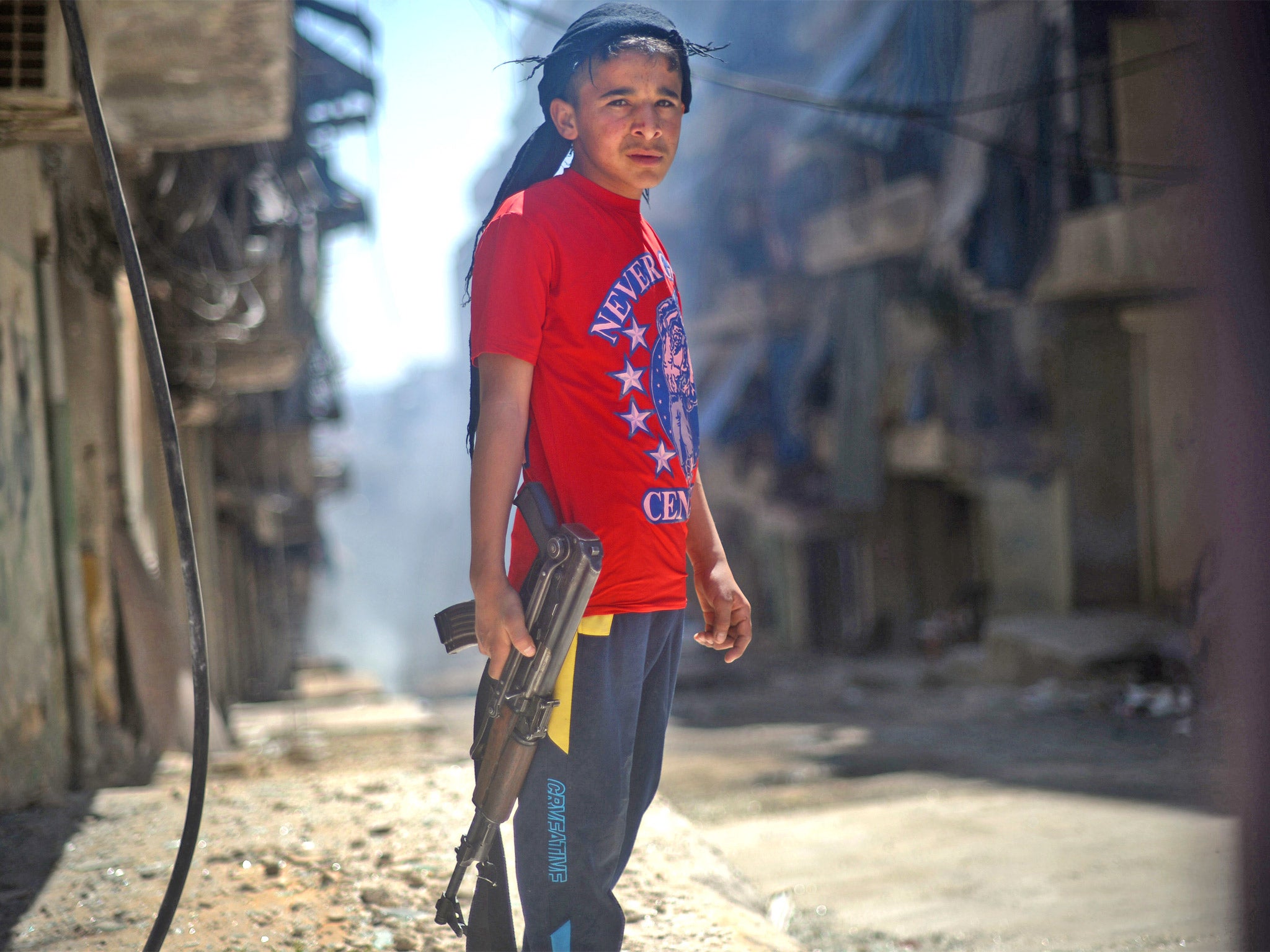 A Syrian boy holds an AK-47 assault rifle in the majority-Kurdish Sheikh Maqsud district of Aleppo (Getty)