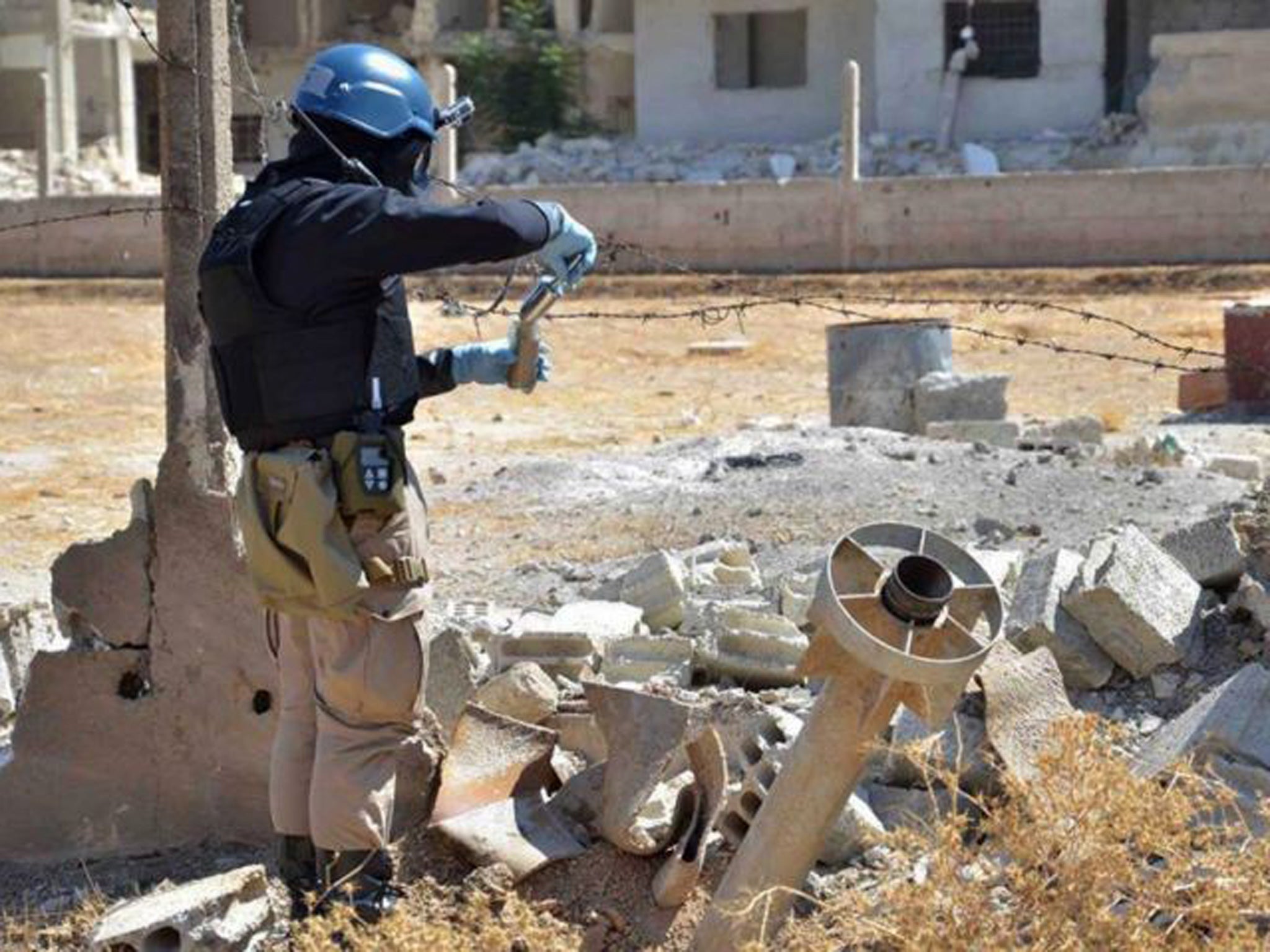 Flashback to August 2013: member of UN investigation team taking samples of sands near a part of a missile in the Damascus countryside