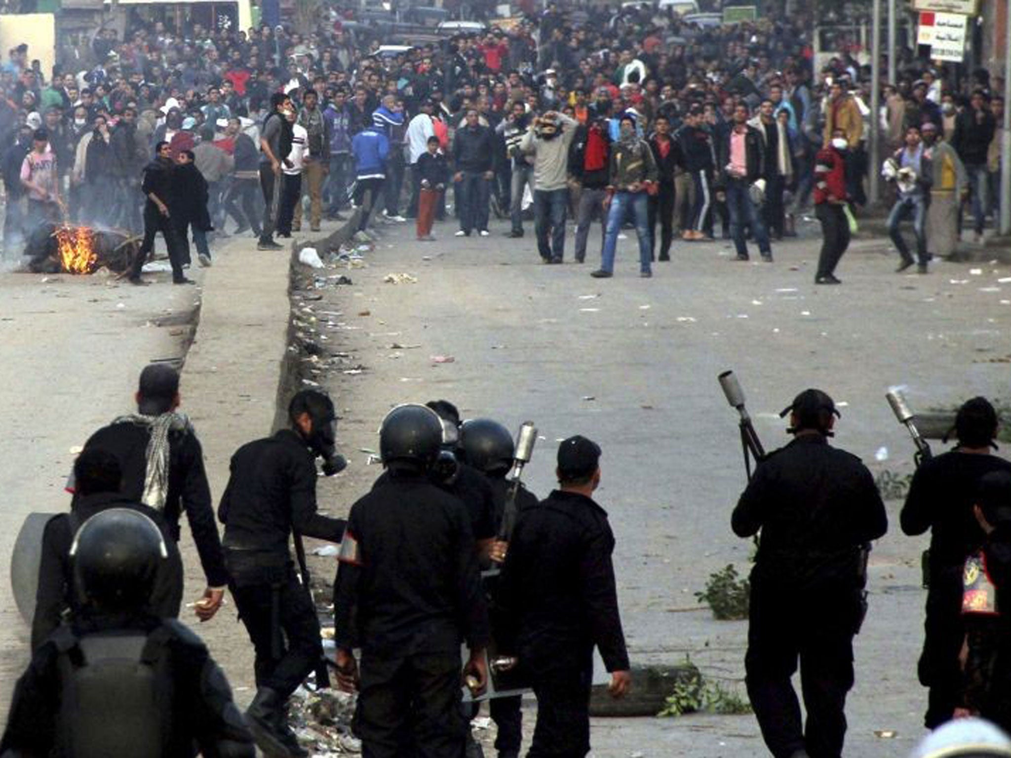 Supporters of the Muslim Brotherhood and ousted Egyptian President Mohamed Mursi run after riot police fired tear gas during clashes in Cairo December 20, 2013