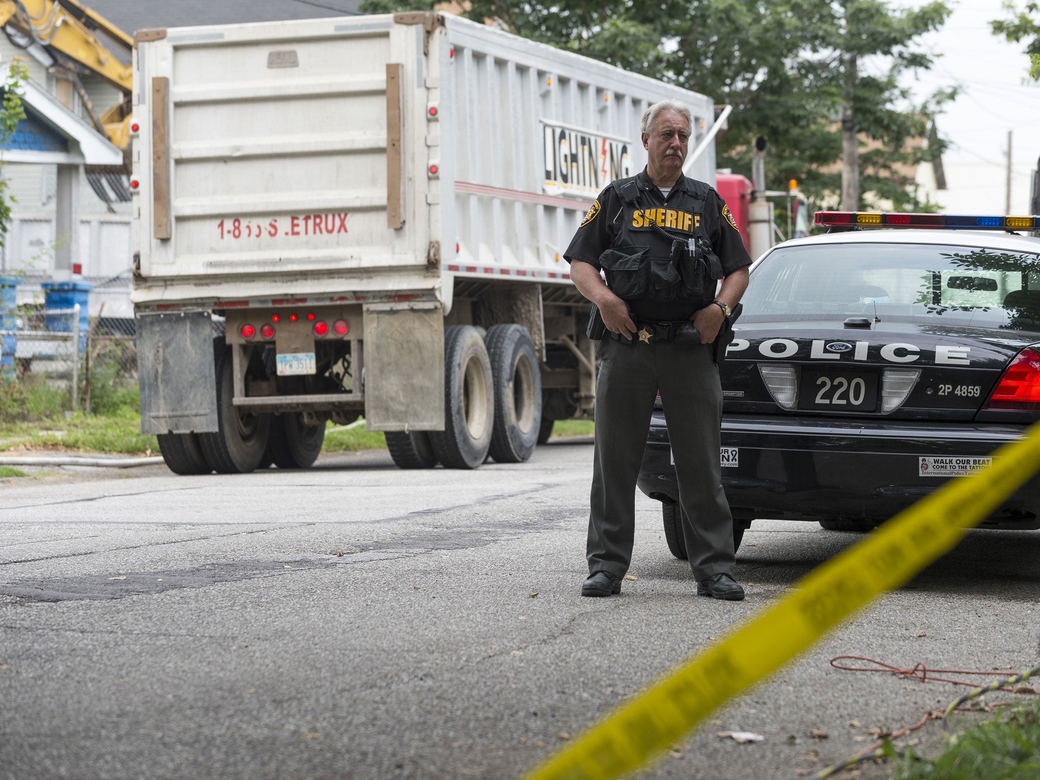 Cleveland Police Officer stands guard in front of the house where three women were held captive for over a decade