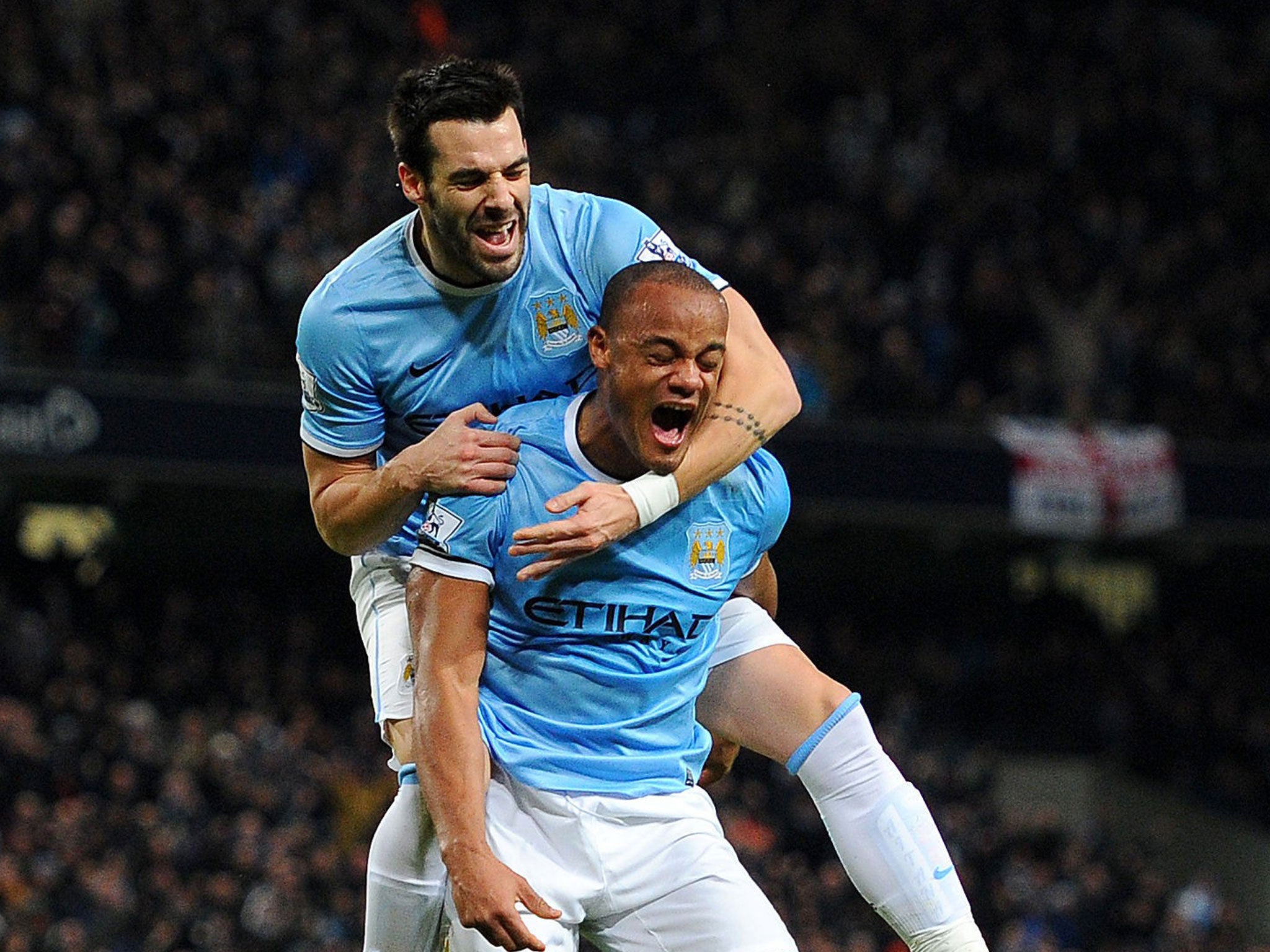 Manchester City's match-winner Alvaro Negredo (top) celebrates with his fellow goalscorer Vincent Kompany at the Etihad