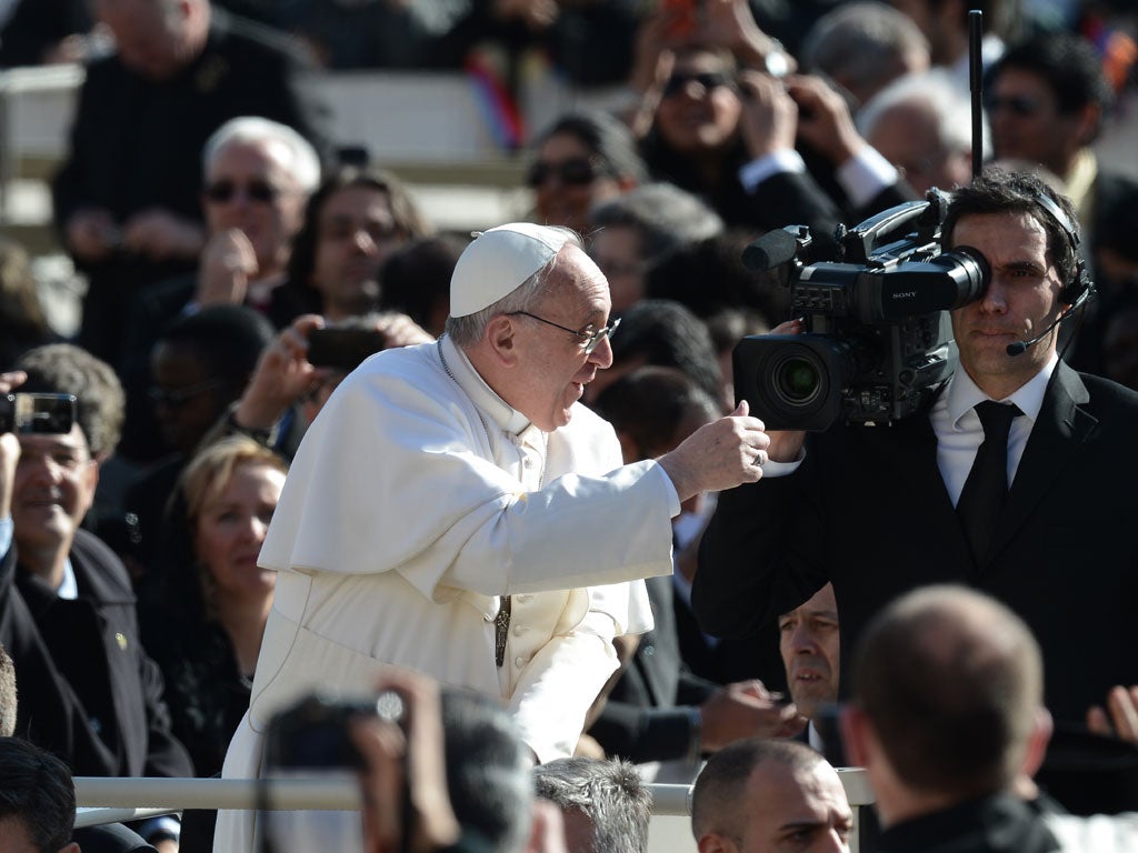 Pope Francis greets the crowd as he arrives for his general audience at the Vatican