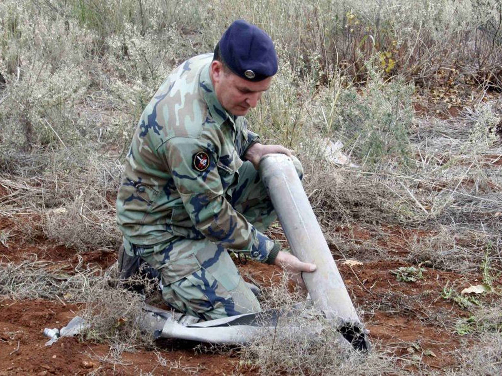 A Lebanese soldier inspects the remains of a shell that landed in the southern Lebanese village of Sarada