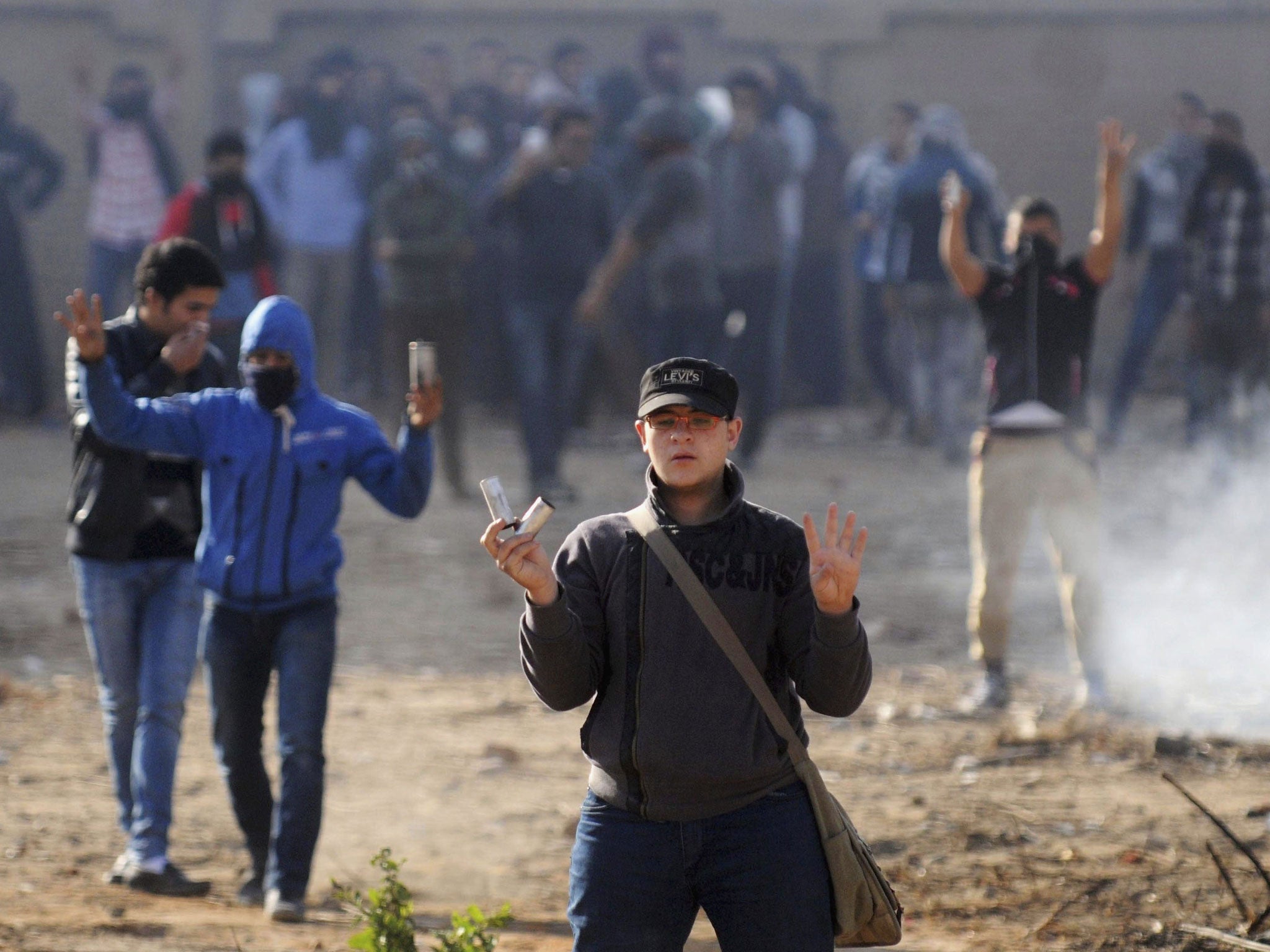 Al-Azhar University students, supporters of Mohamed Morsi and the Muslim Brotherhood, make the four-finger 'Rabaa' gesture during clashes with riot police on Saturday