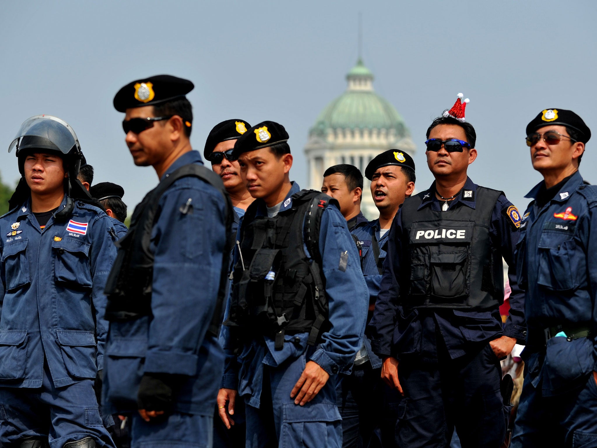 Thai police officers listen as they take part in a peaceful protest at the Royal Plaza in Bangkok