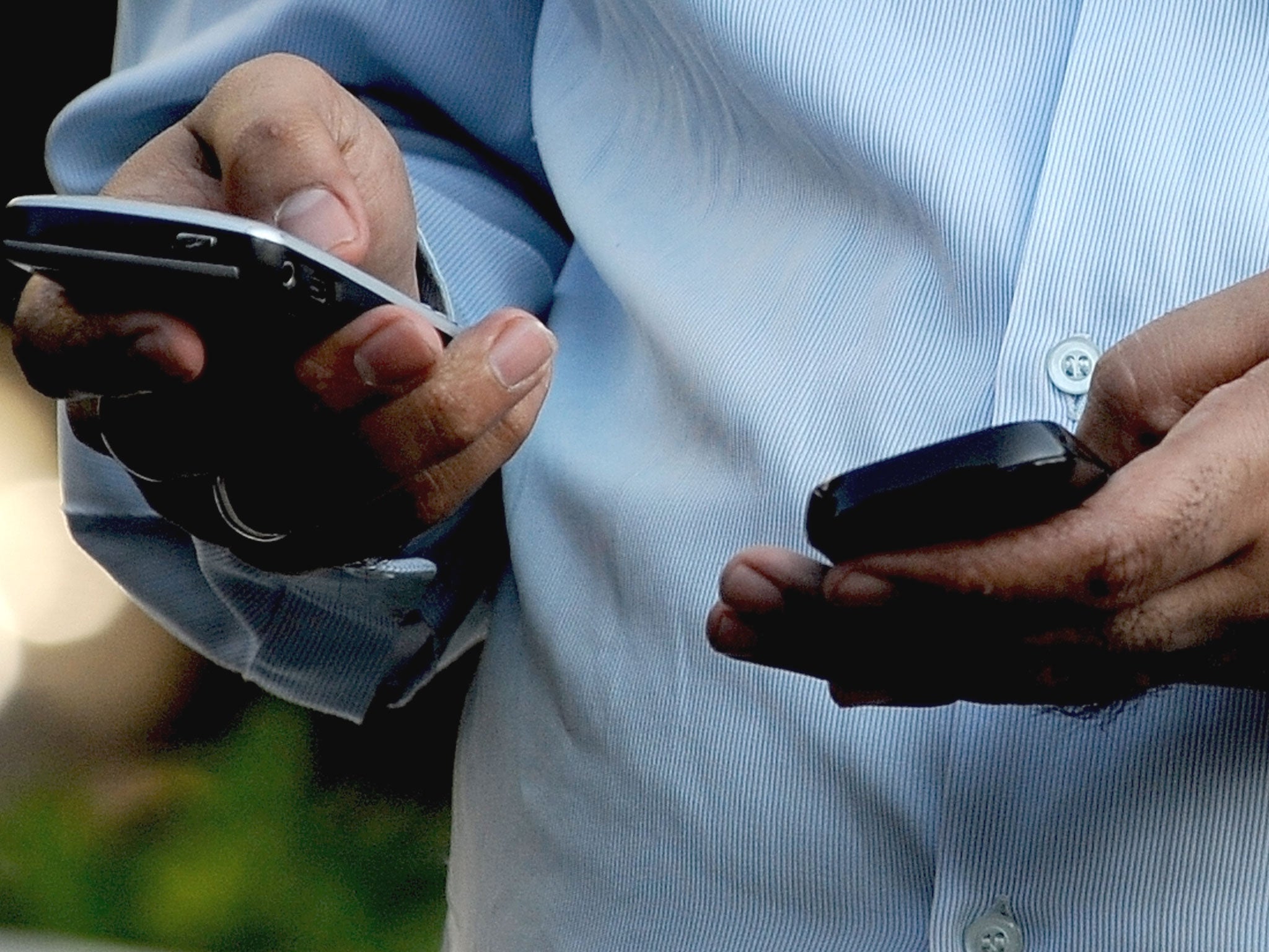 Indian officegoer checks a text message on his mobile phone in Mumbai on September 27, 2011. India's telecom watchdog the Telecom Regulatory Authority of India (TRAI) exempted various service providers, including the dealers of telecom operators, e-ticket