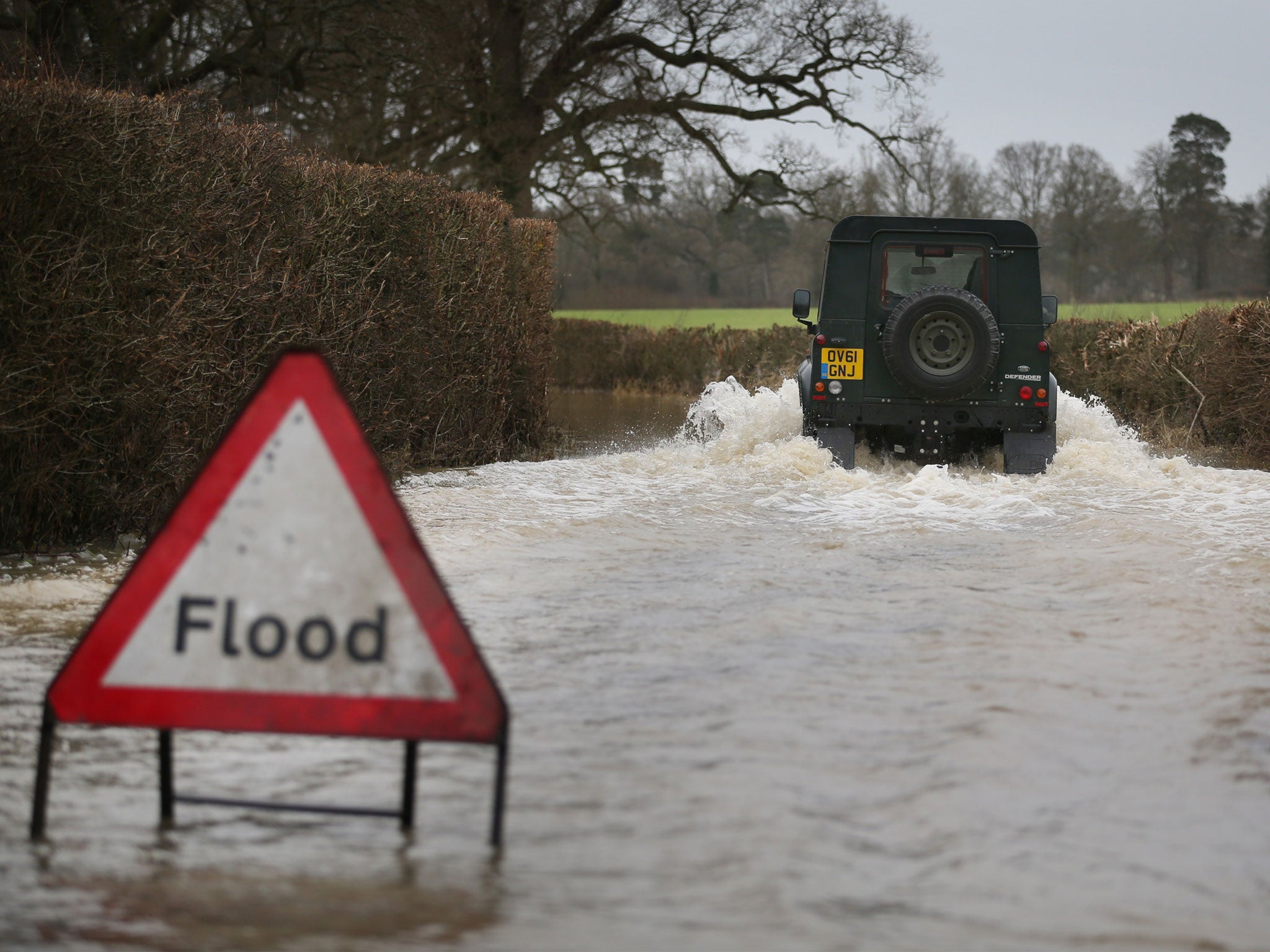 A Landrover makes it's way along a flooded road near Lingfield