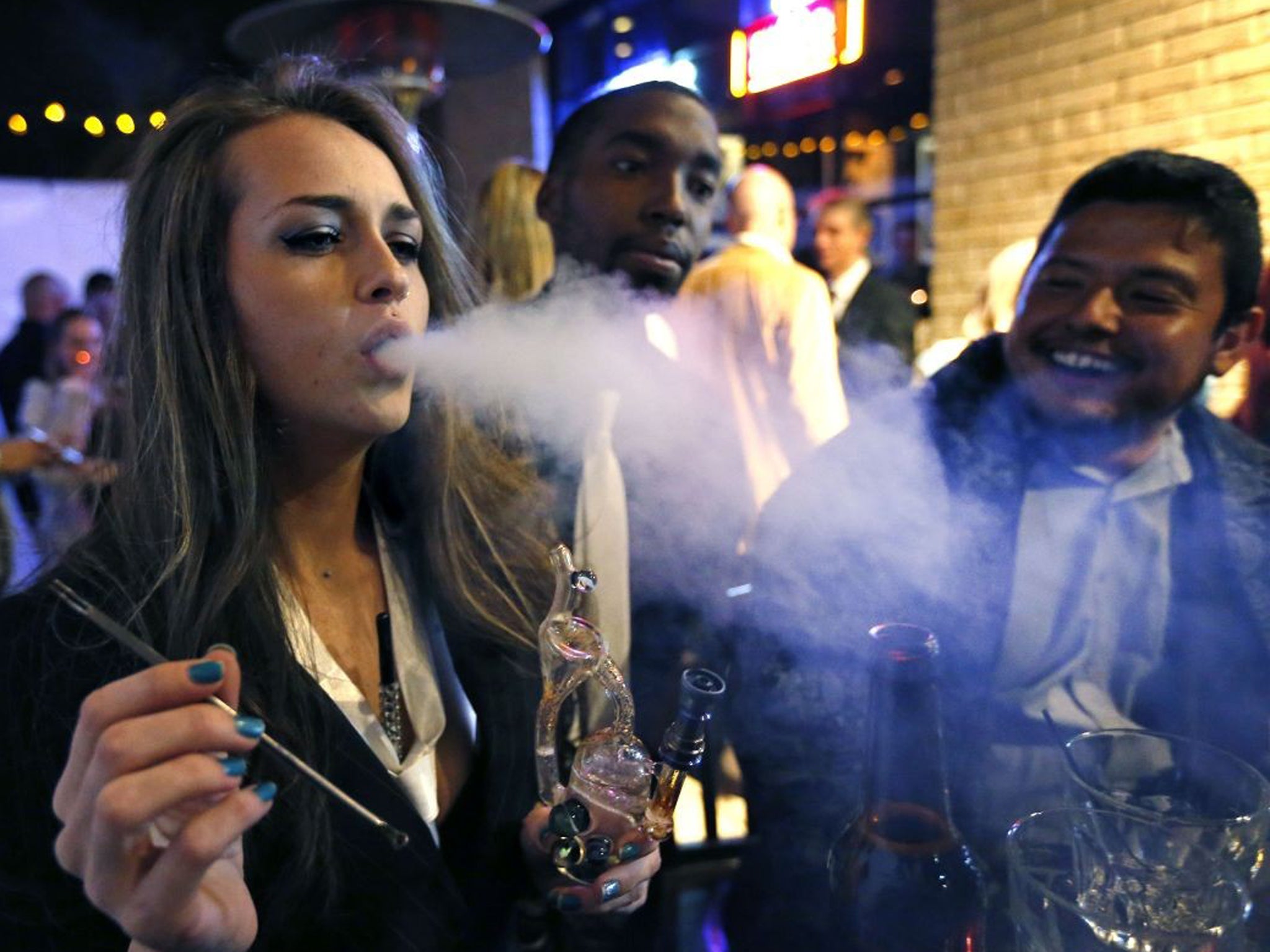 Partygoers smoking marijuana during a party celebrating the start of legal cannabis sales in Colorado