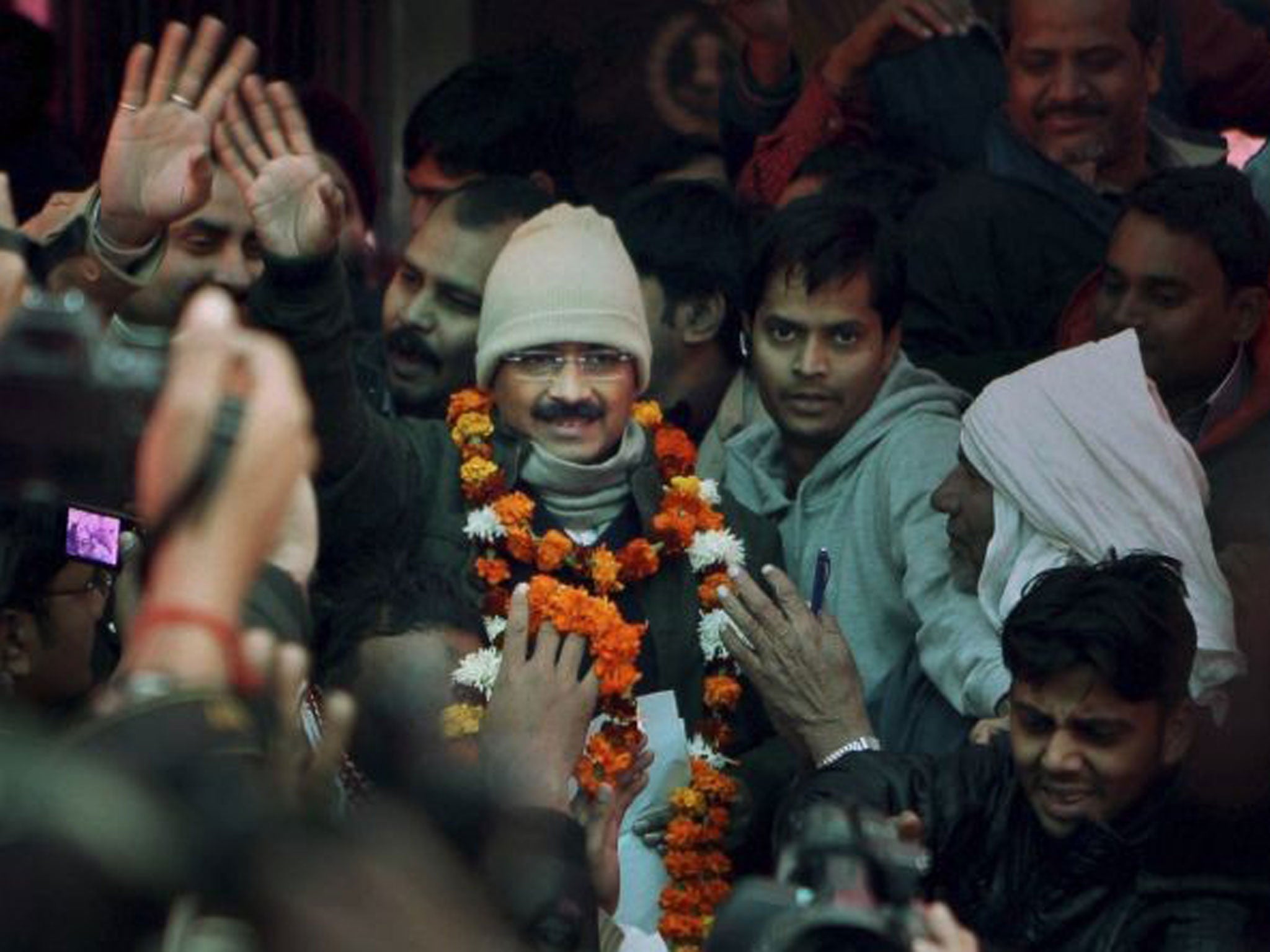 Arvind Kejriwal, center, meets people outside his residence a day after he was sworn in as the Delhi state Chief Minister, in Kaushambi, Ghaziabad, Sunday, Dec. 29,