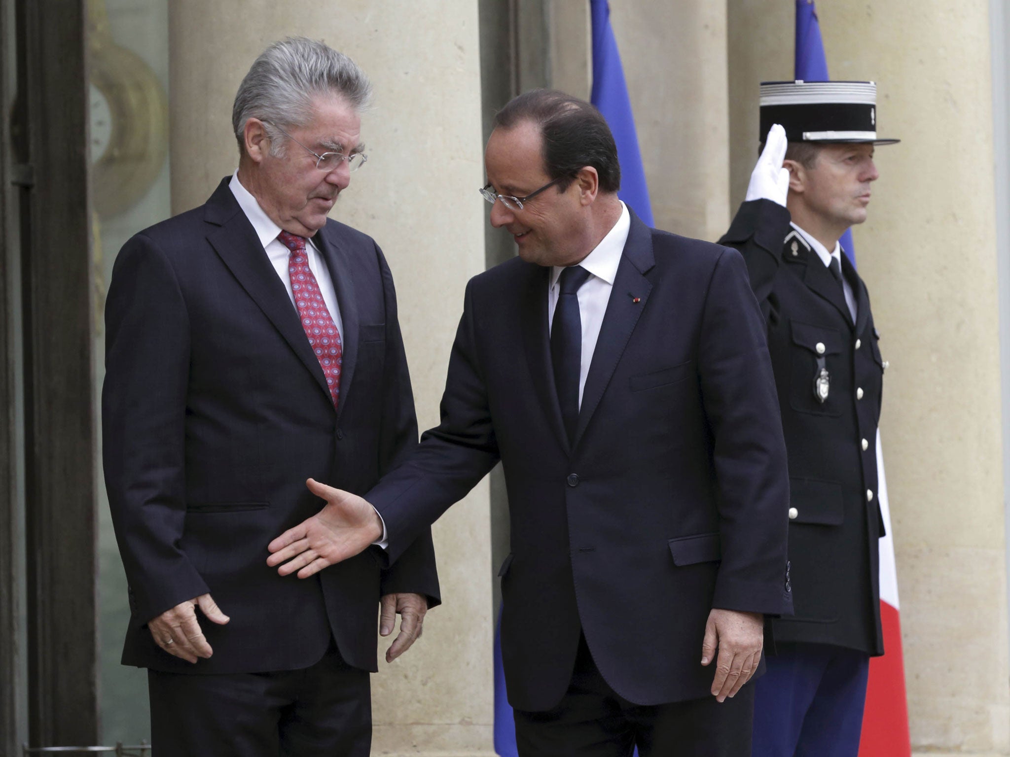 Awkward positioning: Francois Hollande goes for a handshake with Austrian President Heinz Fischer but misses the target