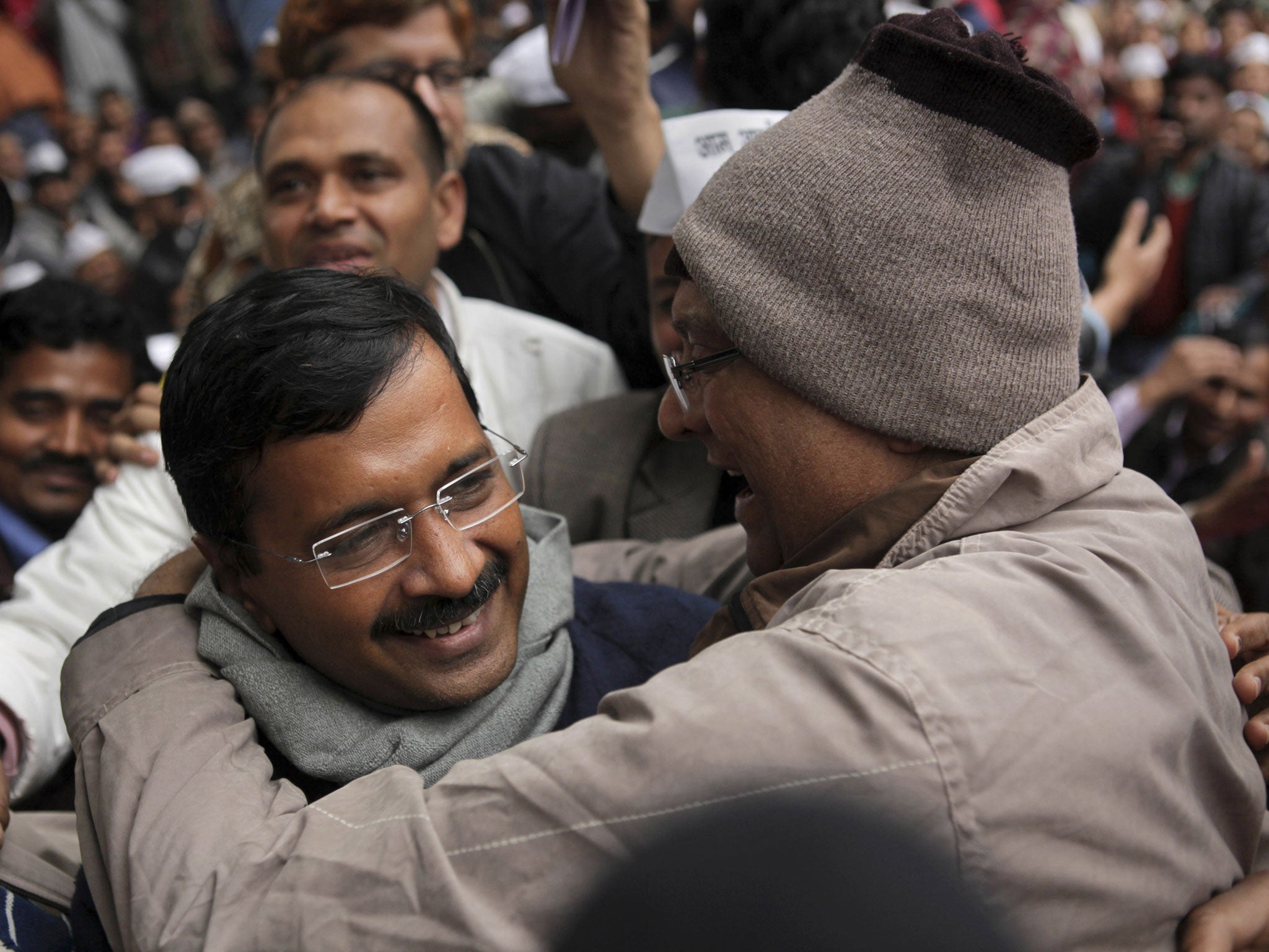 A supporter of Aam Aadmi Party, or Common Man's Party, greets its leader Arvind Kejriwal, left, a former tax official, on his arrival at a public meeting in New Delhi on Sunday