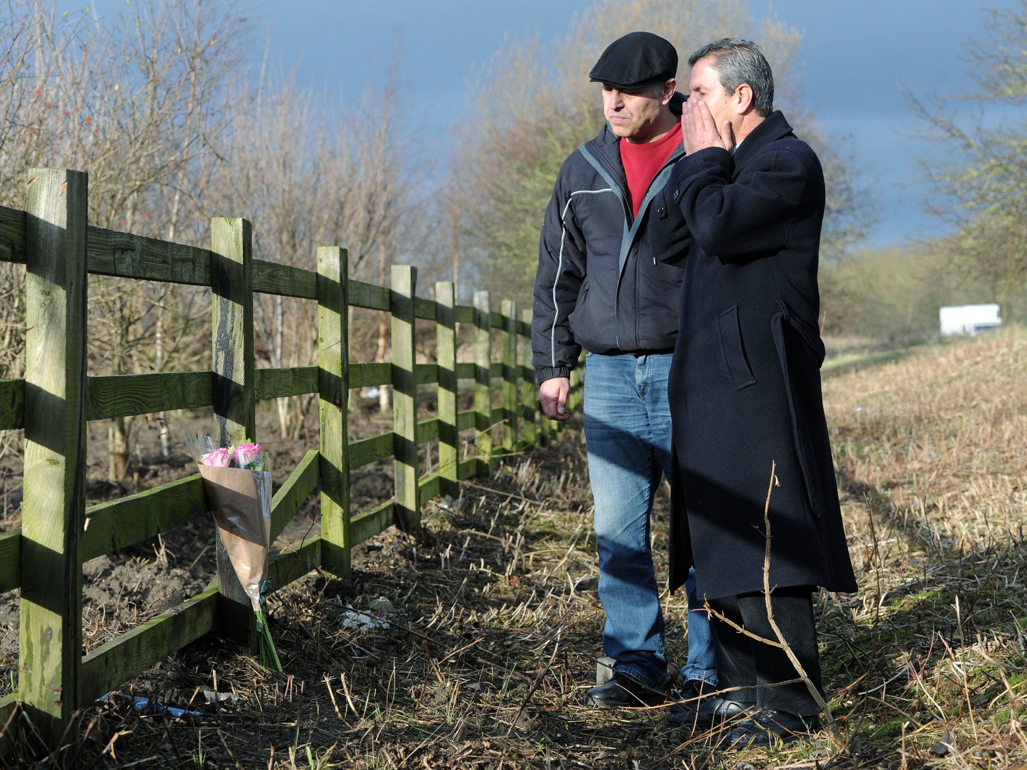 Ali Aydi, right, the uncle of Rania Alayed and a friend put flowers at a layby next to the A19 near Thirsk in North Yorkshire