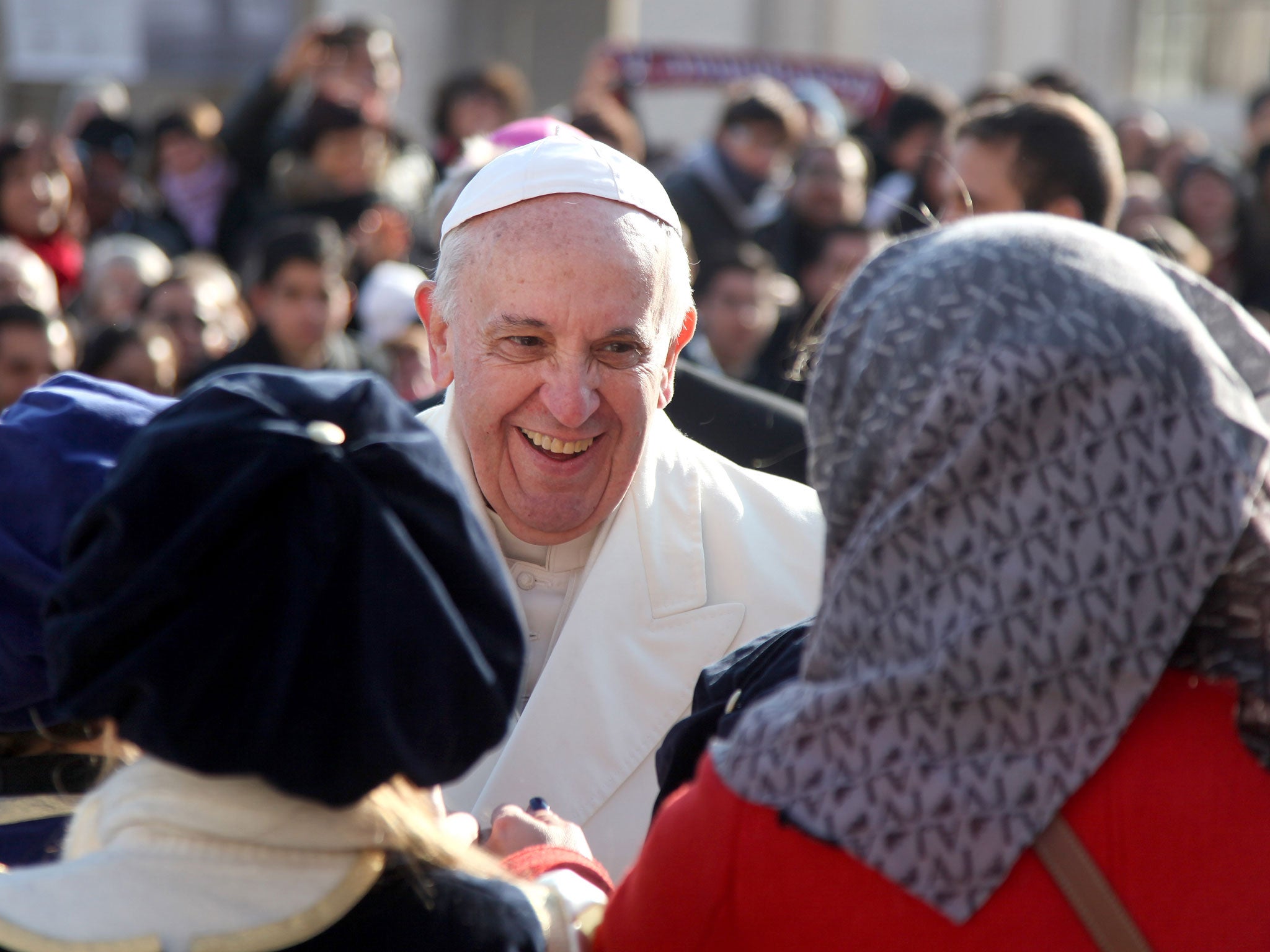 Pope Francis greets a group of children as he leaves his weekly Audience in St. Peter's Square on December 18, 2013 in Vatican City, Vatican.