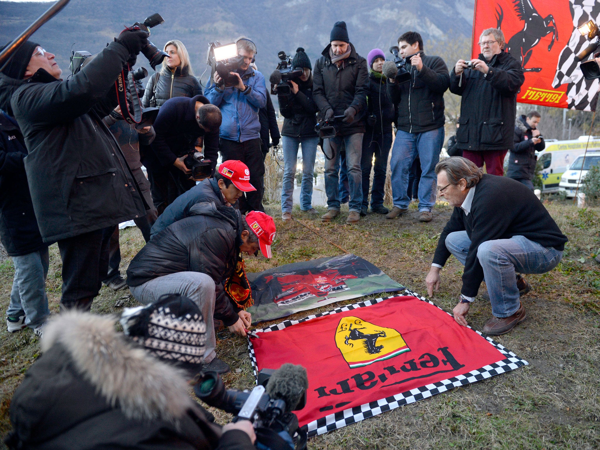 Fans of Michael Schumacher and Ferrari lay down flags to support the former F1 world champion in a show of support as he continues to fight for his life