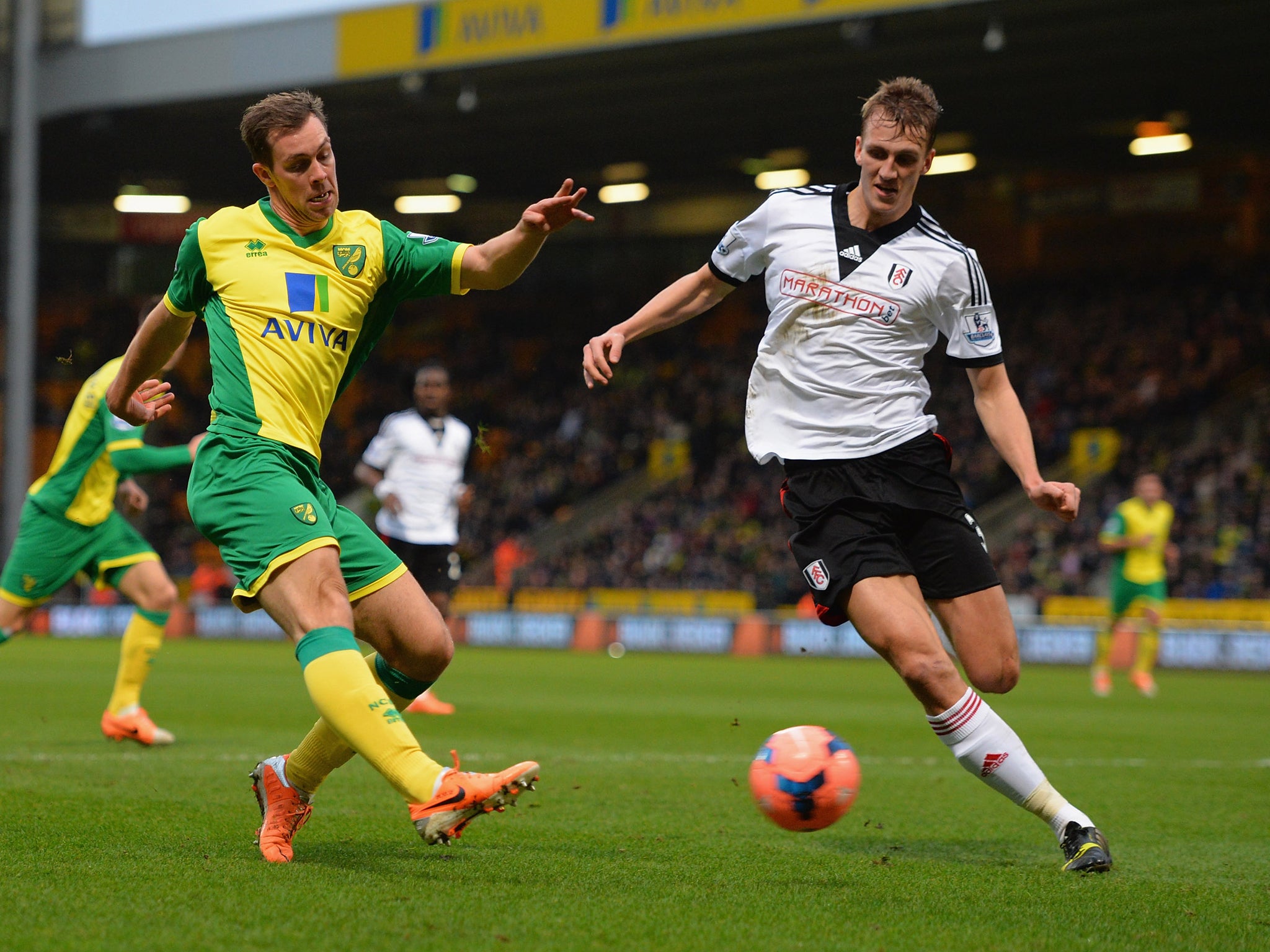 Norwich right-back Steven Whittaker tries to shoot past Fulham defender Dan Burn