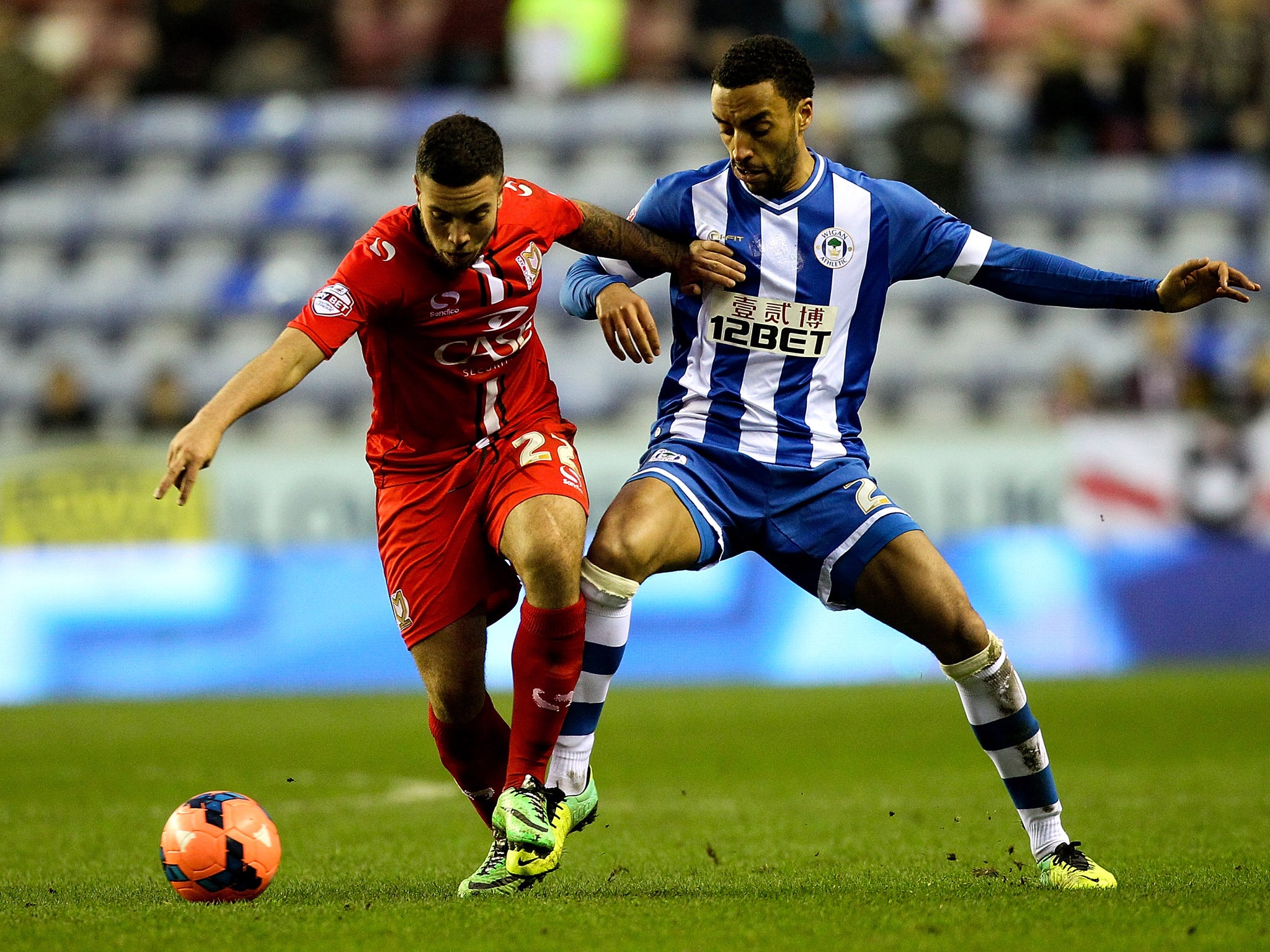 Sam Carruthers of MK Dons battles with James Perch of Wigan