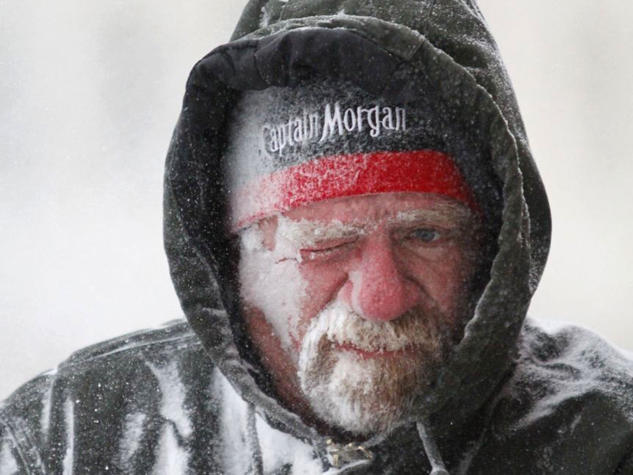 Allan Umscheid, owner of Yards By Al in Lawrence, Kan, feels the bitter wind and catches drifting snow on his face as he runs a snow blower early morning