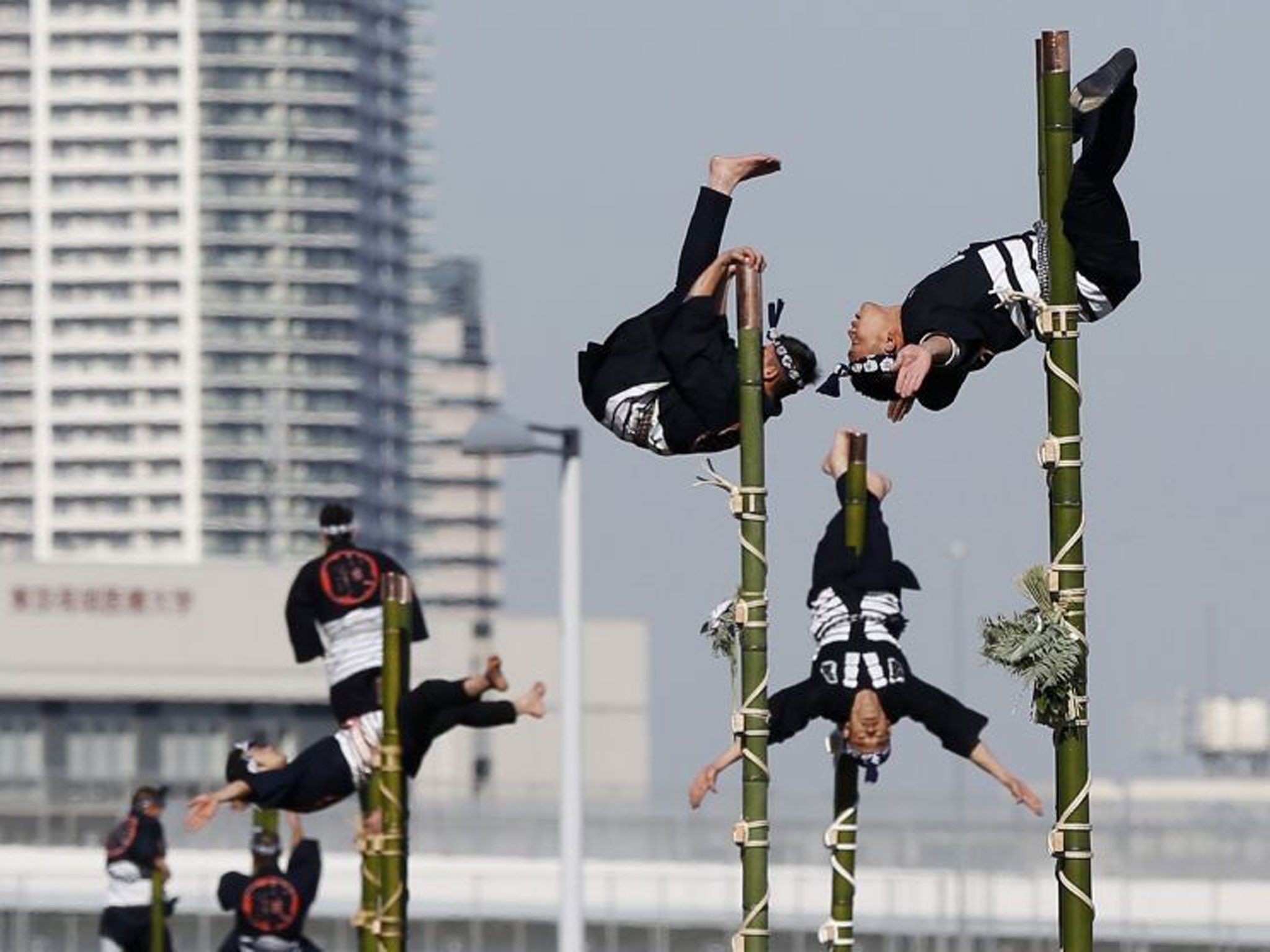 Members of the Edo Firemanship Preservation Association display their balancing skills atop bamboo ladders during a New Year demonstration by the fire brigade in Tokyo