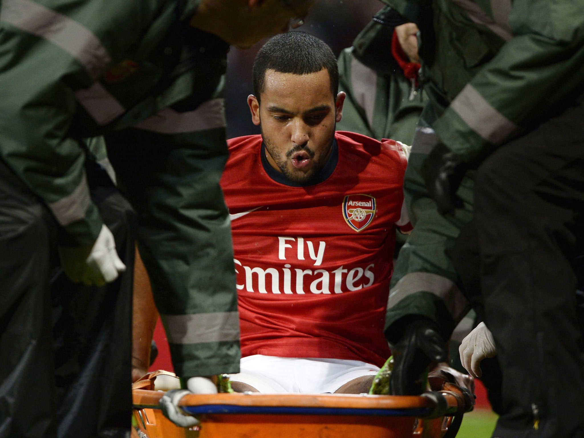 Theo Walcott is stretchered off the pitch during the match against Tottenham Hotspur (Reuters)