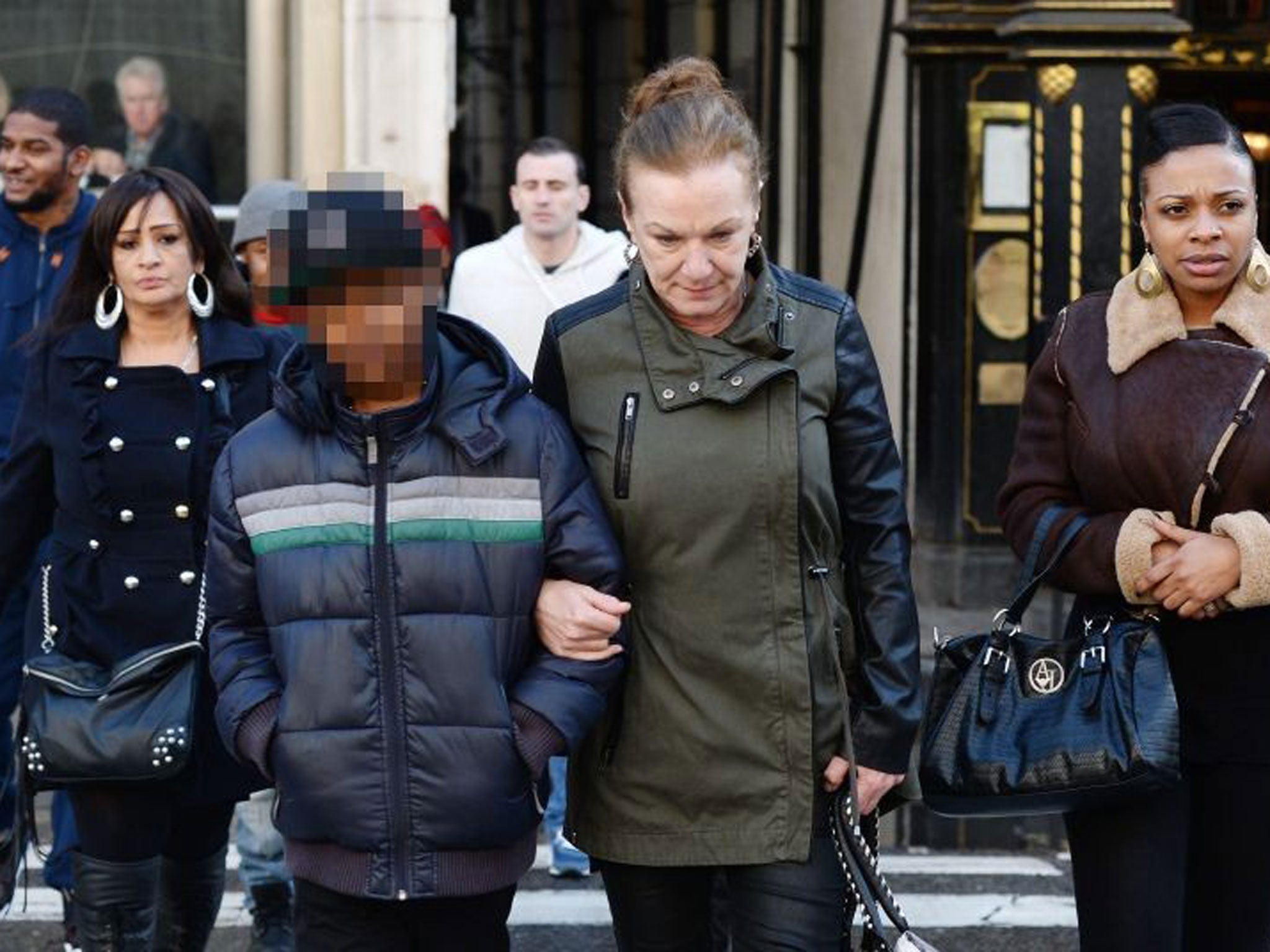 Mark Duggan's family members, Carrol Duggan (C) arrives at the High Court with Mark Duggan's son (L) in central London