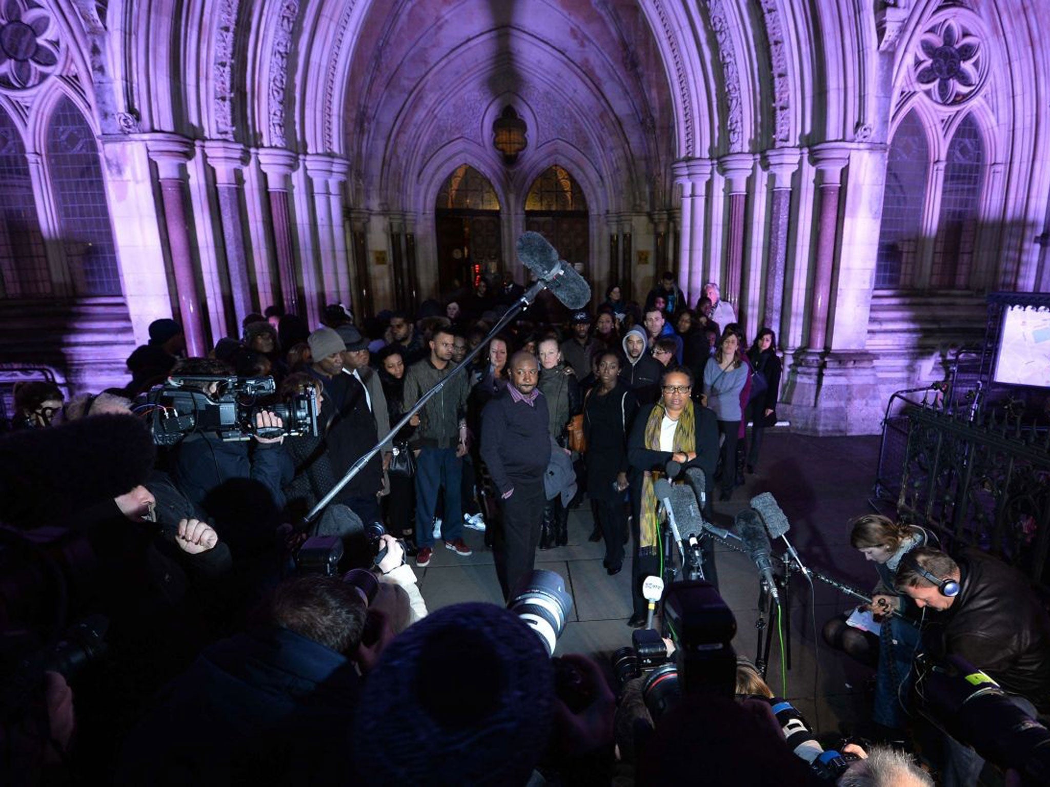 Relatives and supporters of Mark Duggan address the waiting media outside the Royal Courts of Justice in London