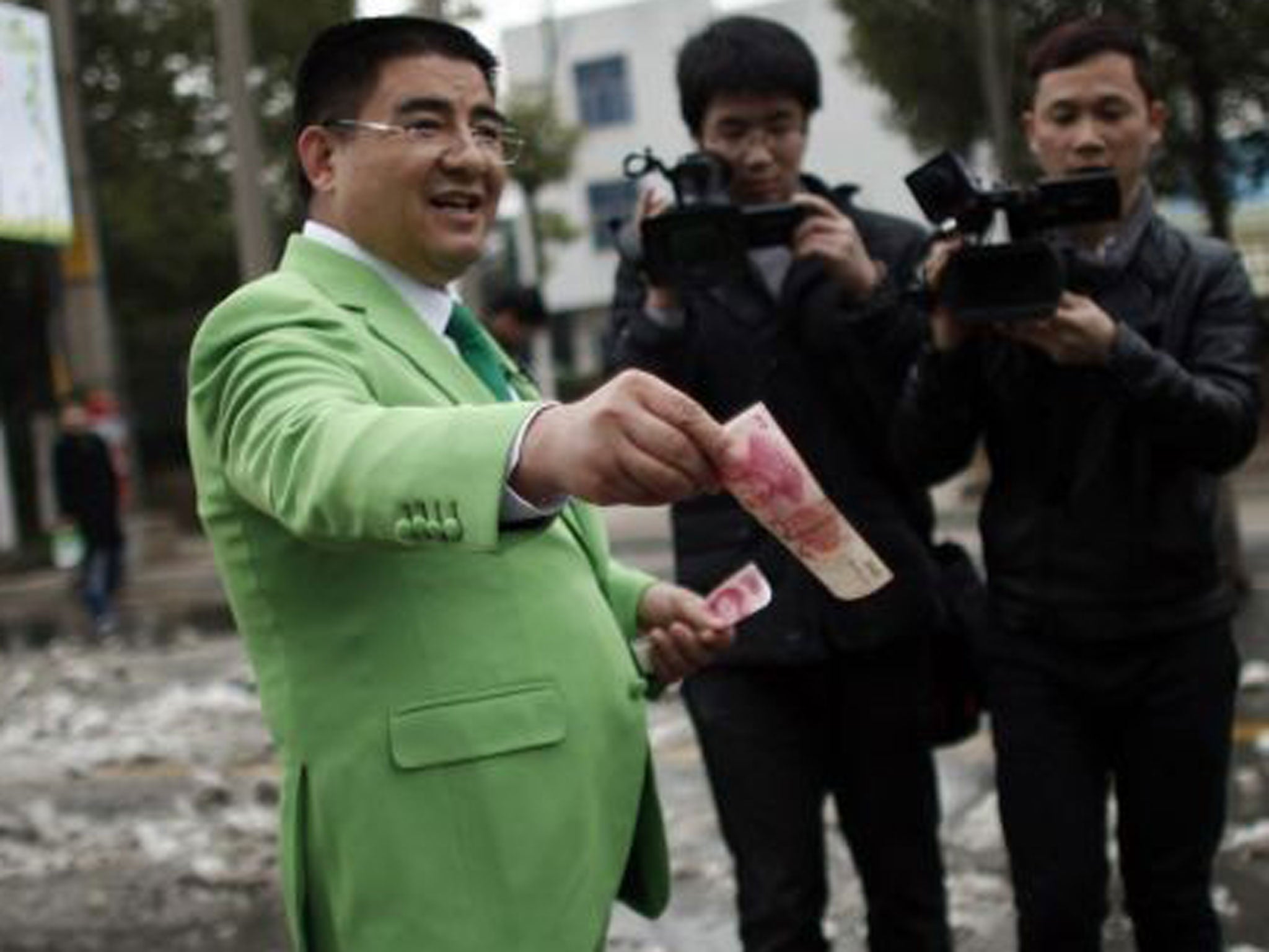 Chen Guangbiao gives money away to street cleaners during an event he organised in Nanjing, Jiangsu