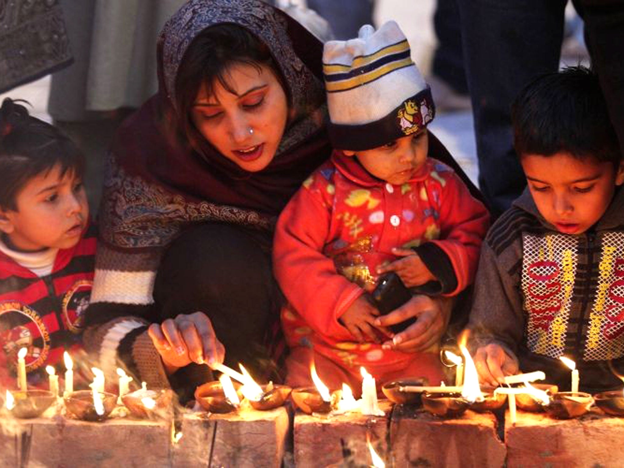Pakistani Muslim devotees light candles while visiting the shrine of Saint Mian Mir Sahib, during an event marking the 369th death anniversary of the saint in Lahore